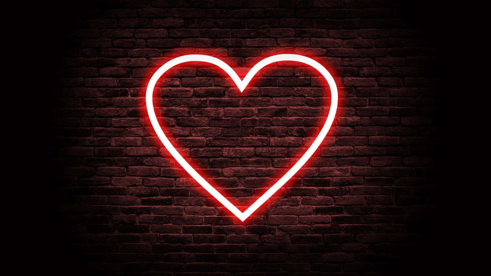 A neon heart sign on brick wall - Neon red
