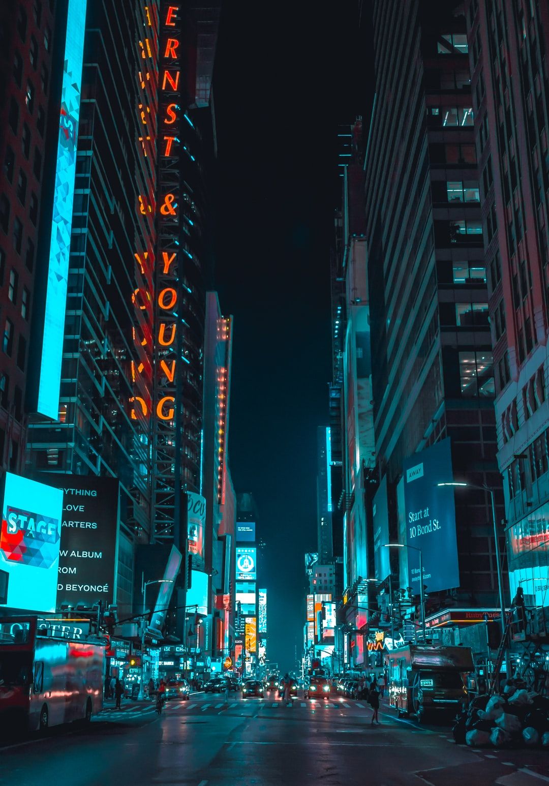 A city street at night with neon lights - New York