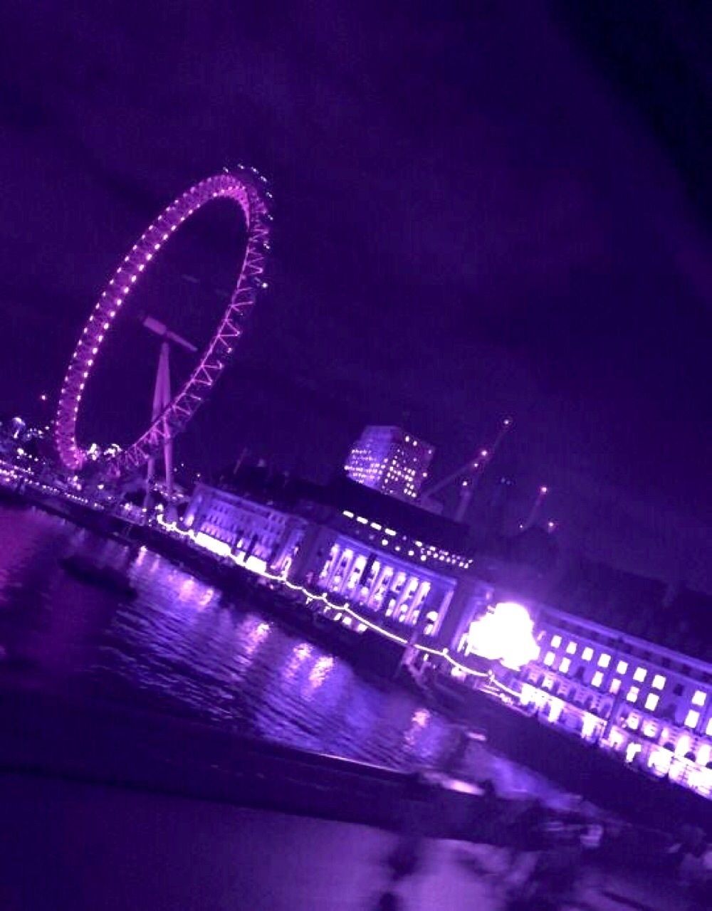 A purple lighted ferris wheel in the city - City