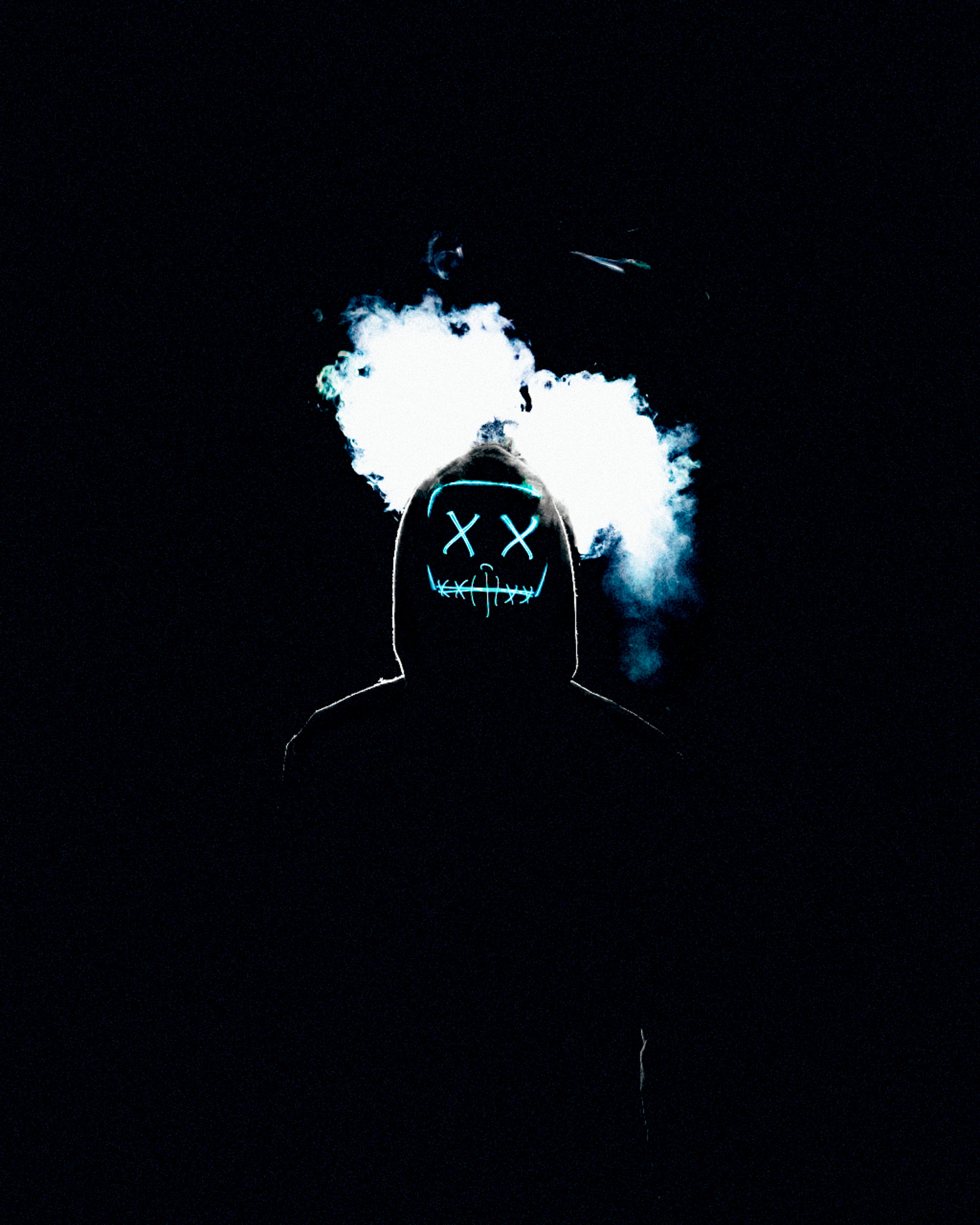 A hooded figure with a scary face on a black background with smoke - Smoke