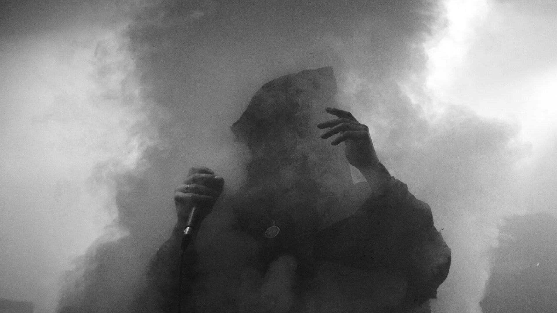 A person in black and white with smoke coming out of the background - Smoke