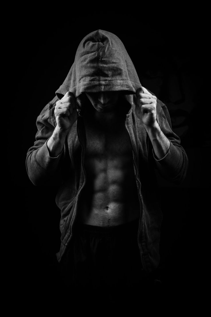 A man in a hooded sweatshirt with his shirt open, revealing his abs. - Gym