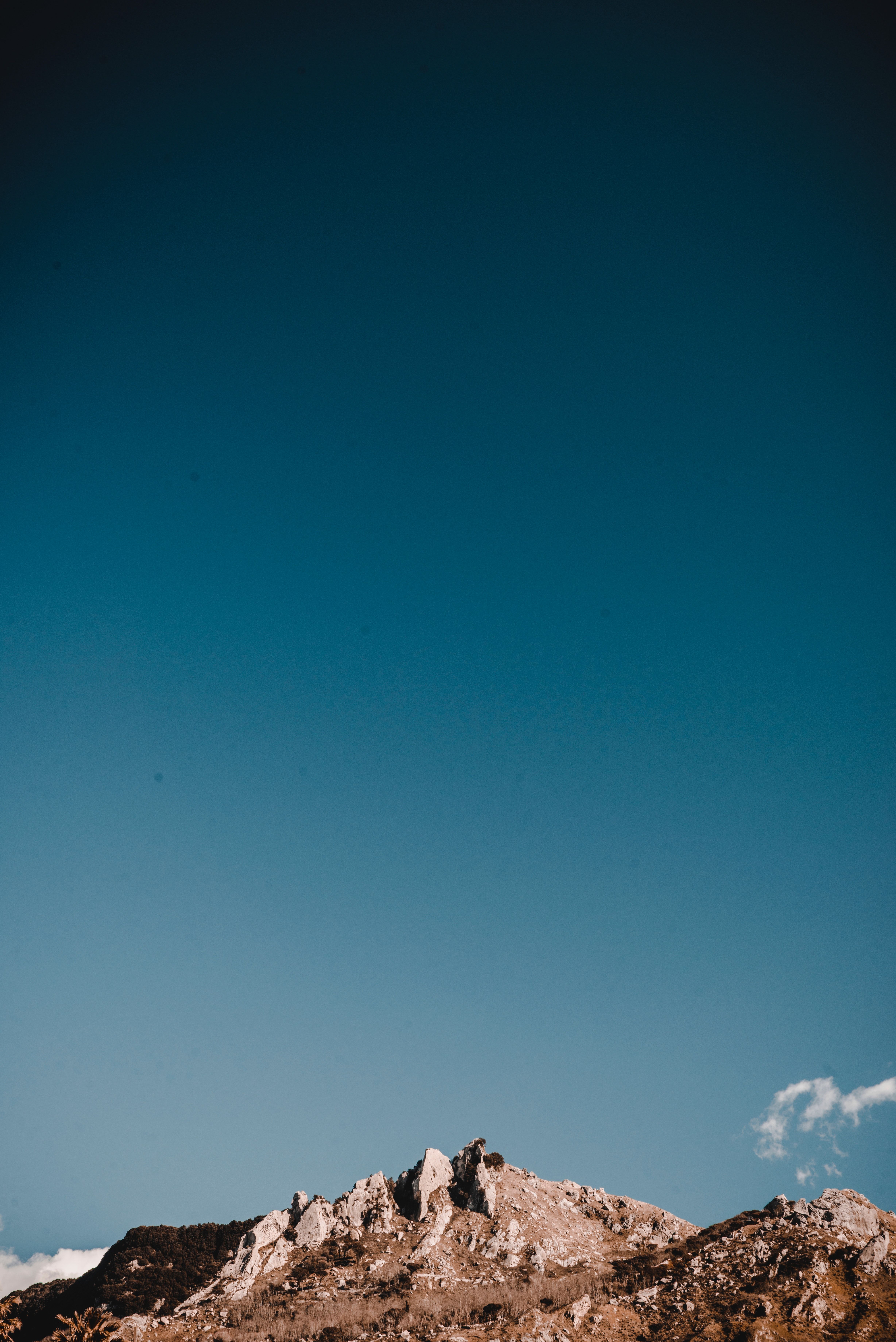 A mountain peak with a clear blue sky above it. - Rocks