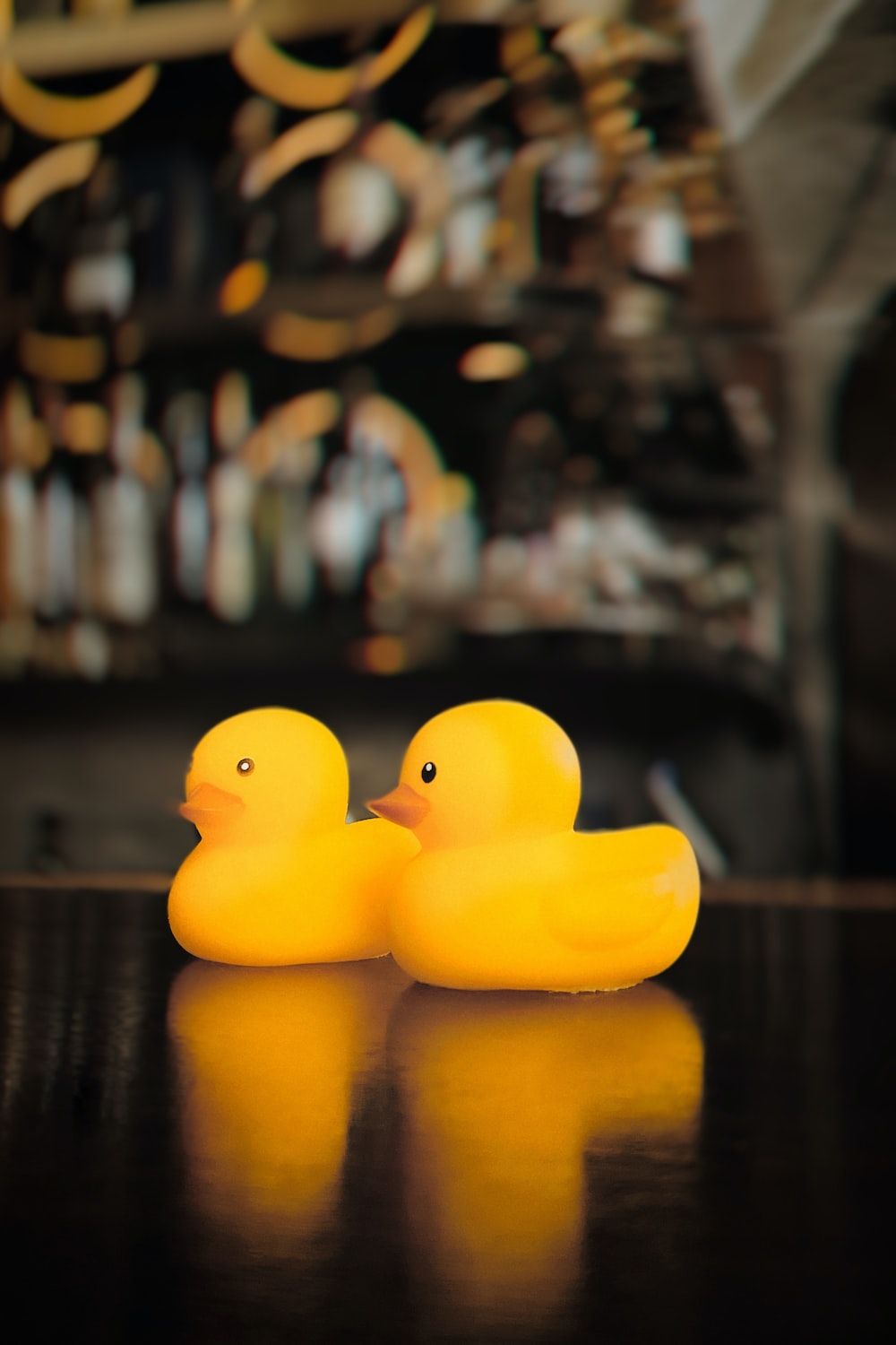 Two yellow rubber ducks on a table - Duck
