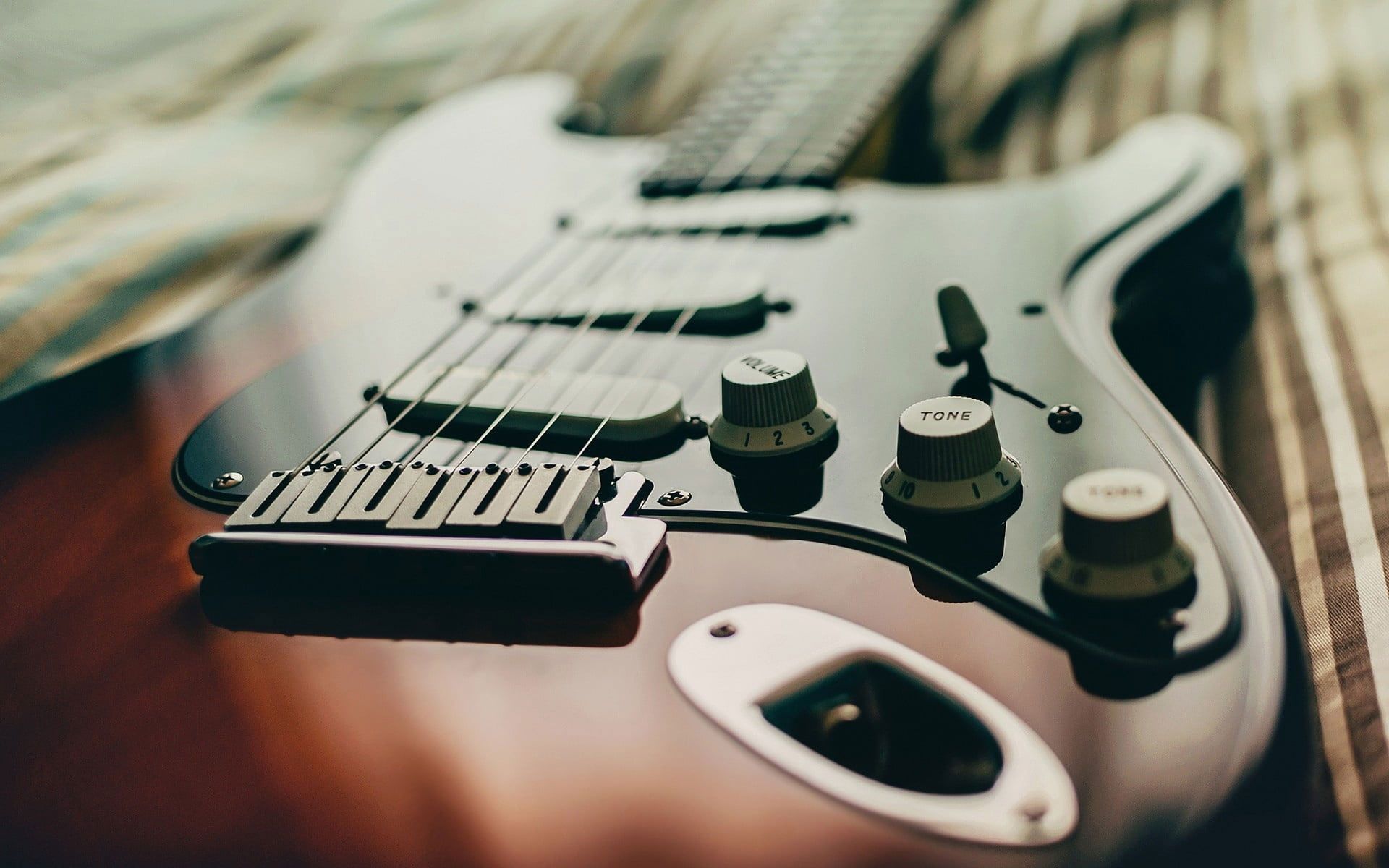 A close up of a guitar with many knobs and buttons. - Guitar