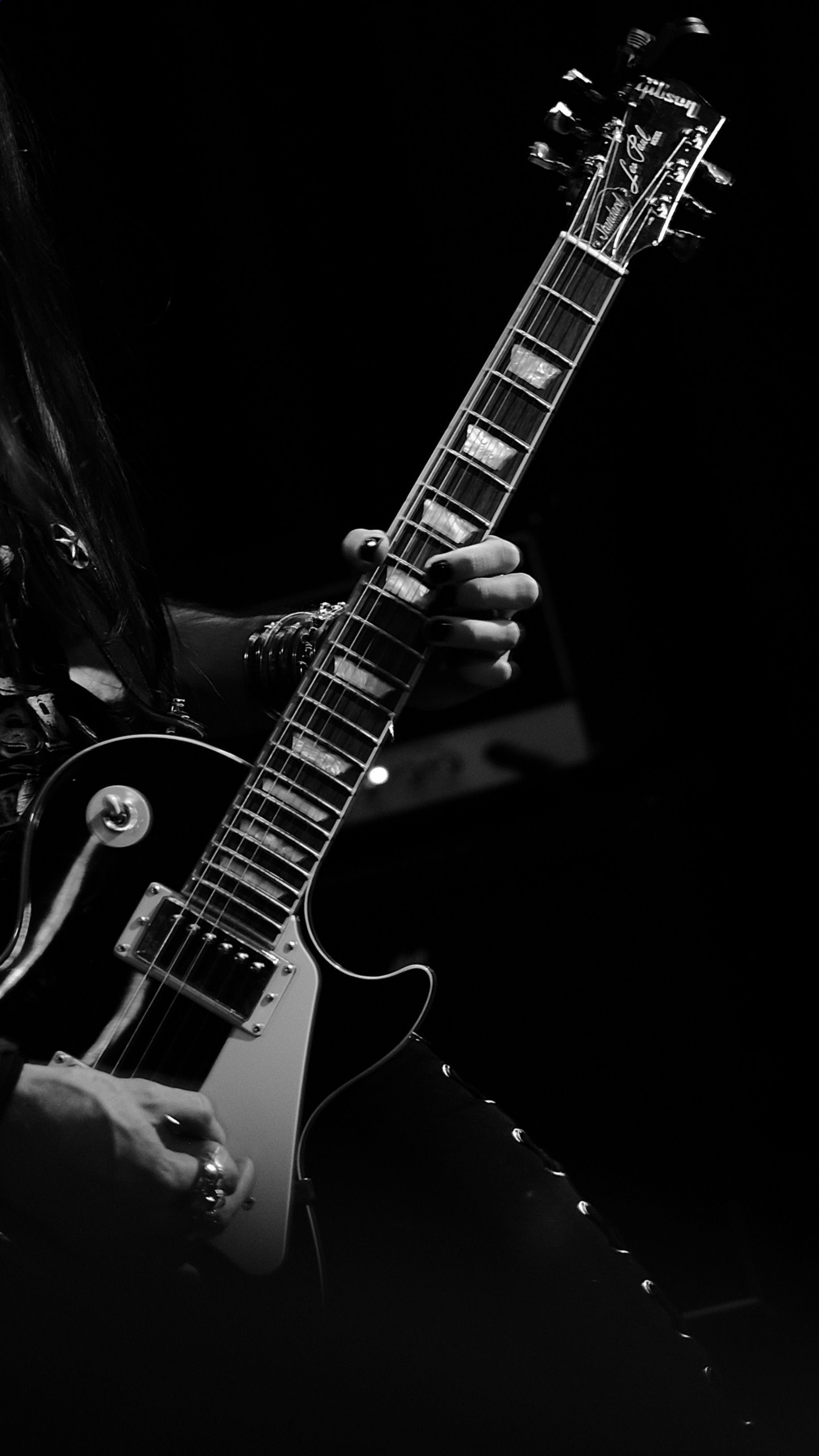 A person playing an electric guitar in black and white. - Guitar
