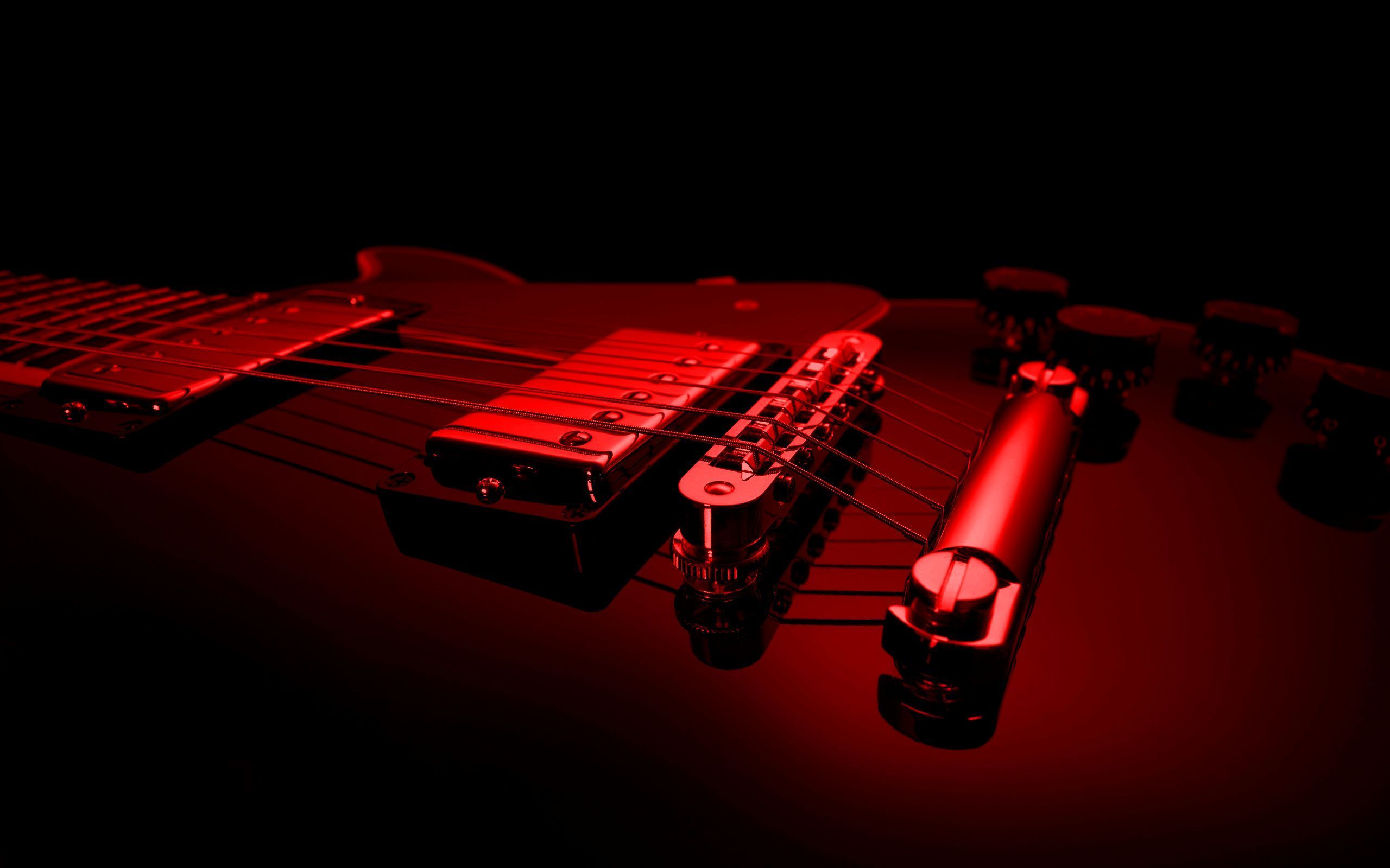 A red electric guitar on a black background - Guitar