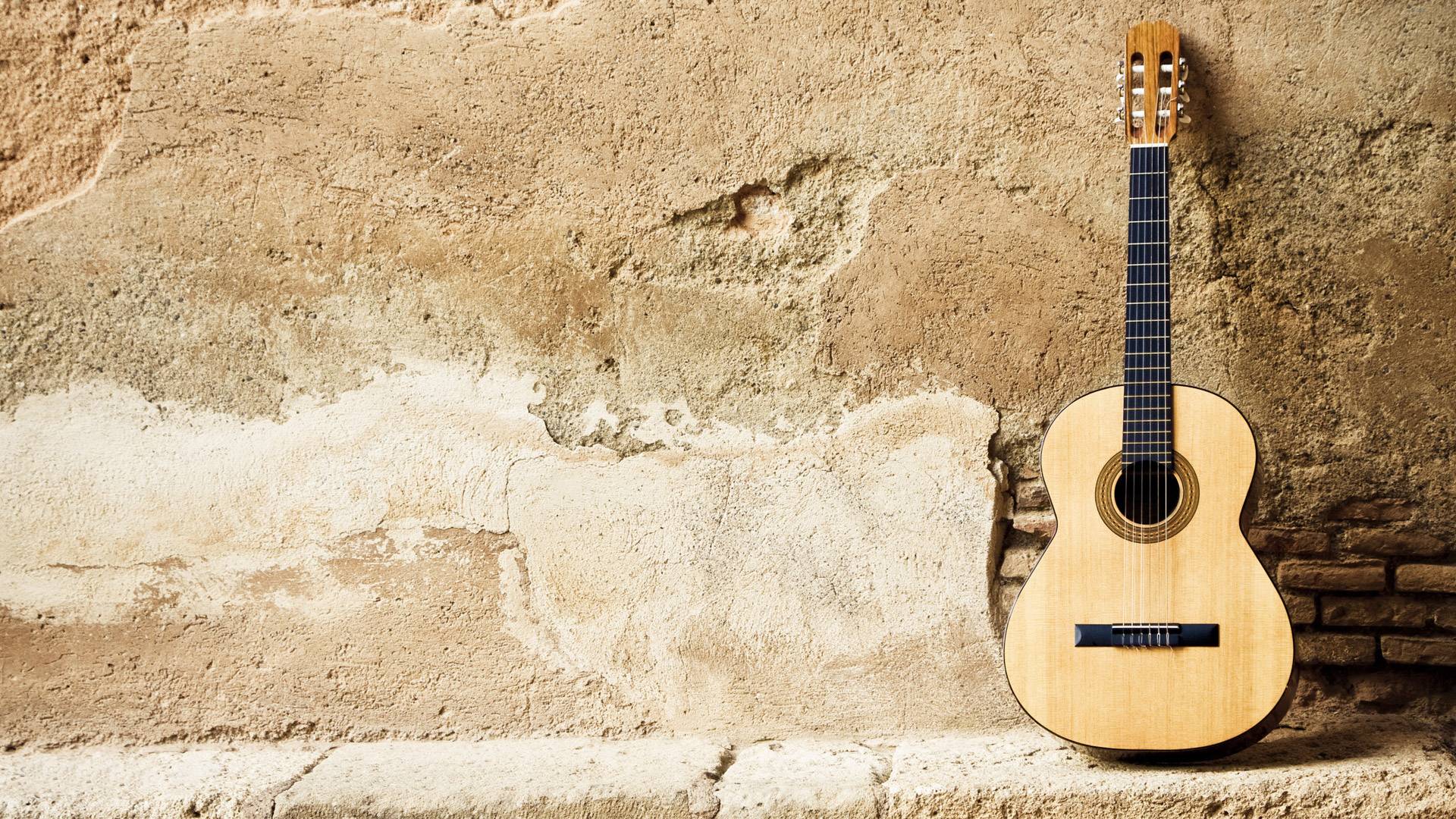 An acoustic guitar leaning against a wall - Guitar