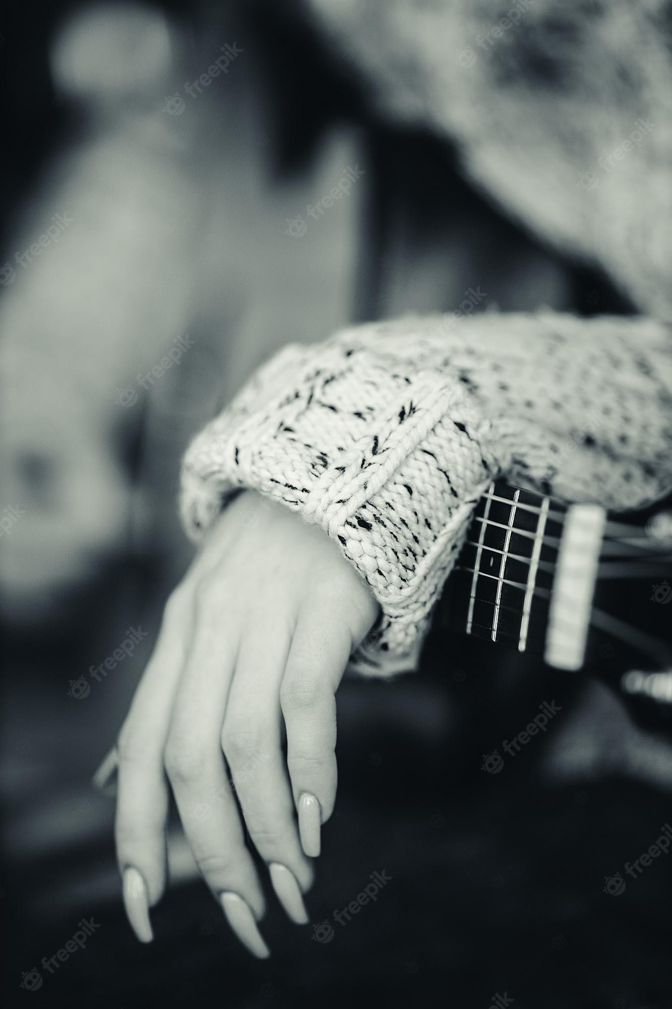 A woman's hand holding an acoustic guitar - Guitar