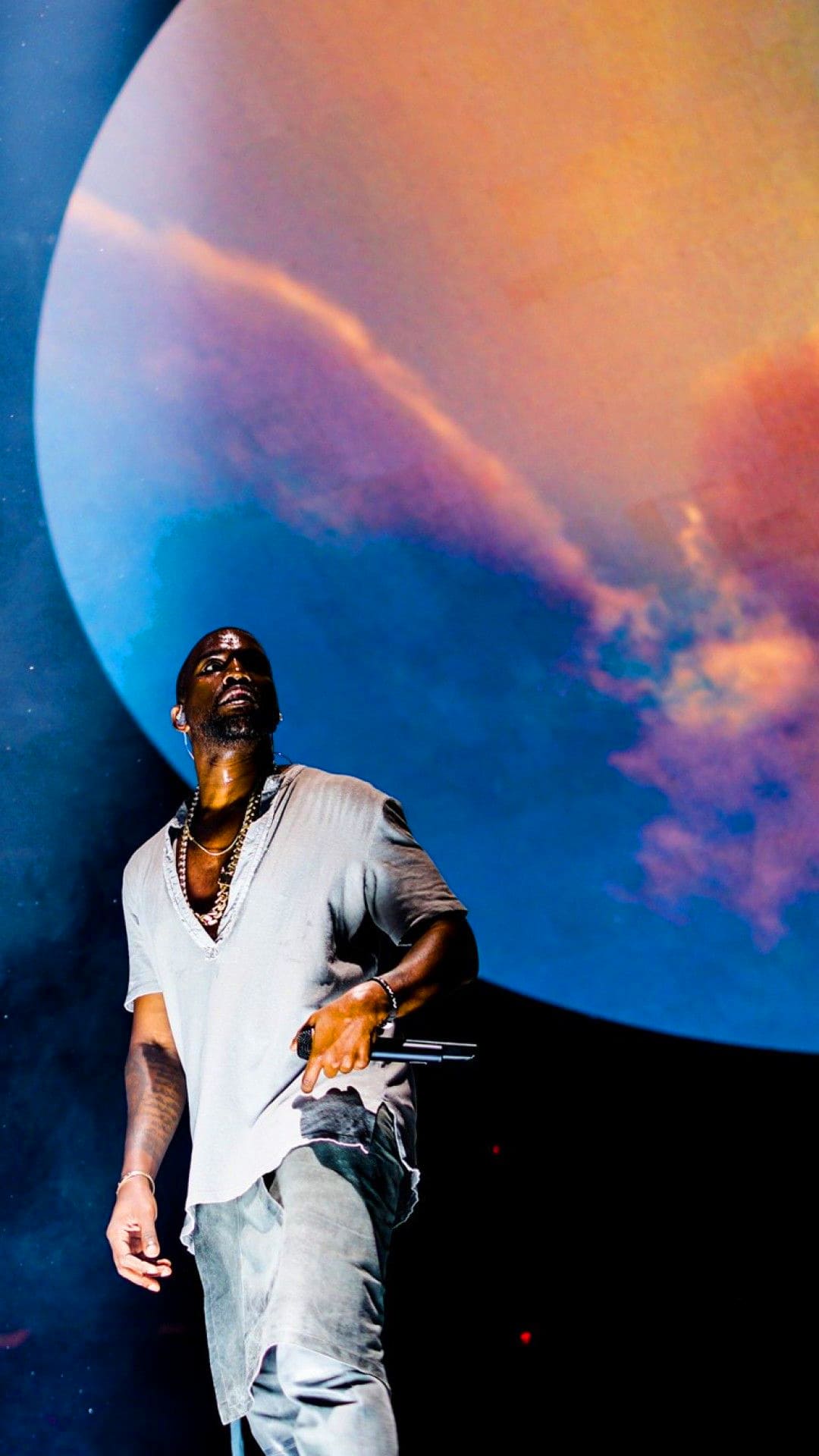 Kanye West performs on stage in front of a planet - Kanye West