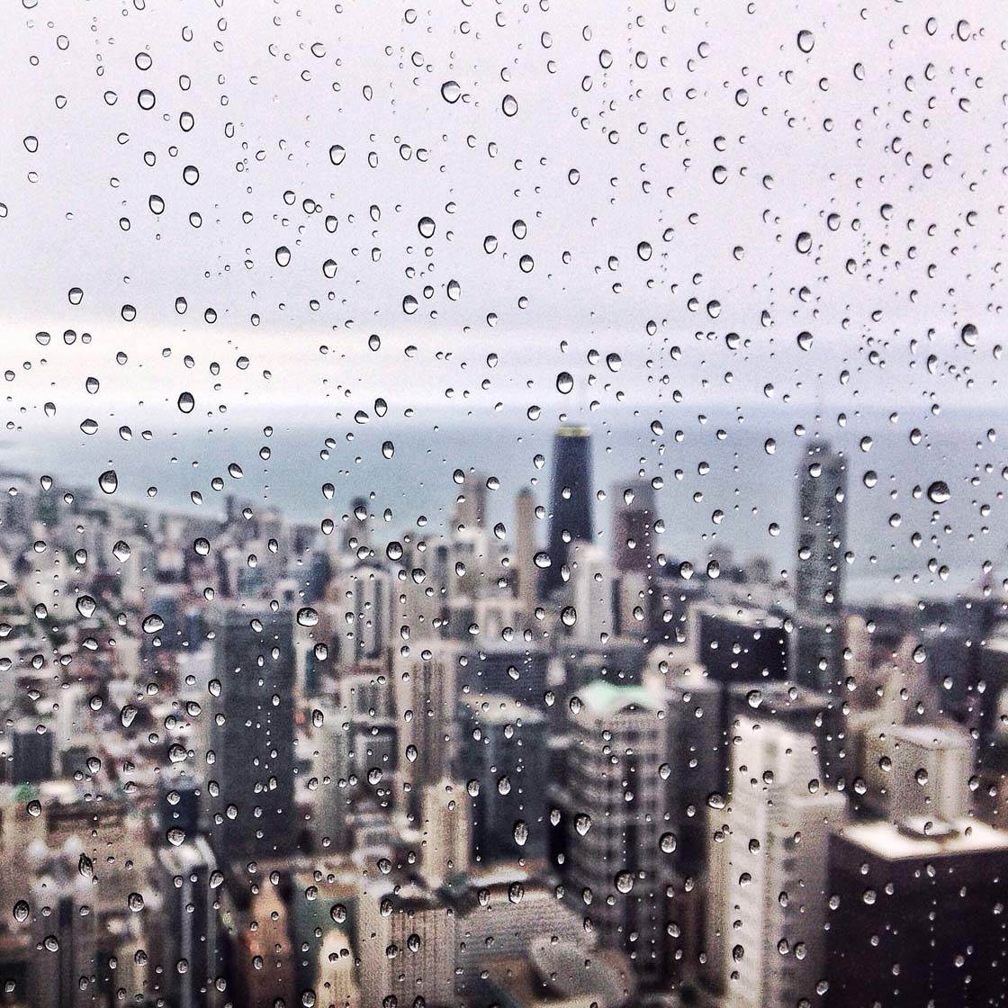 Raindrops on a window overlooking a city - Rain