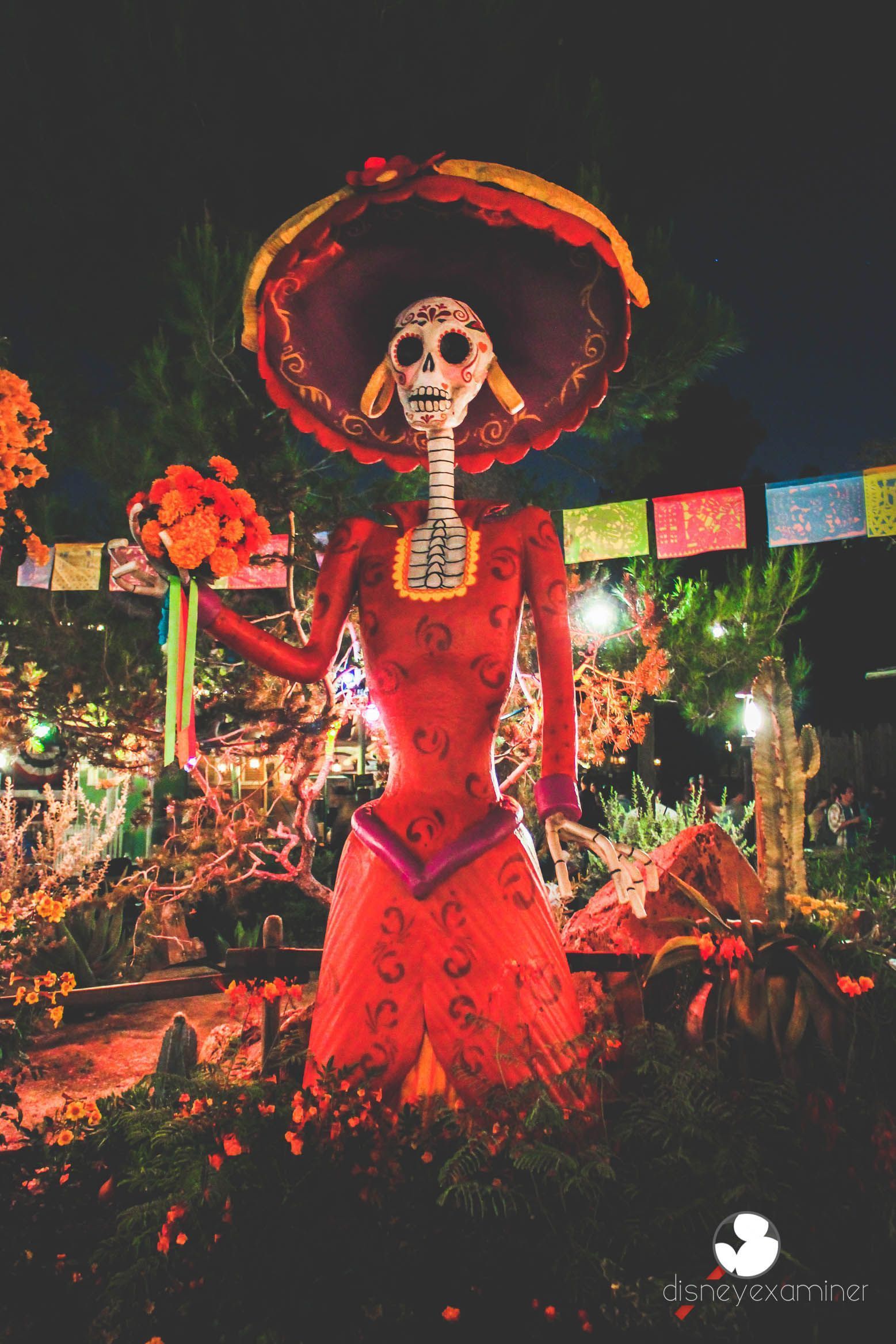 A skeleton dressed in red and holding flowers - Disneyland