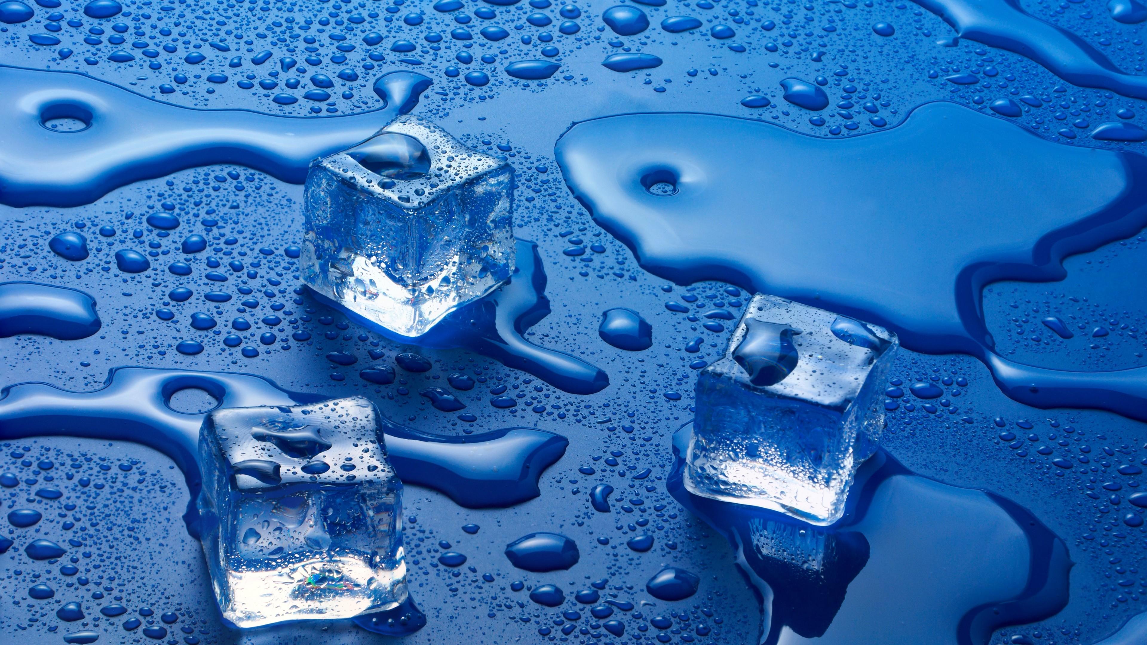 Blue ice cubes and water drops on a blue background - Ice