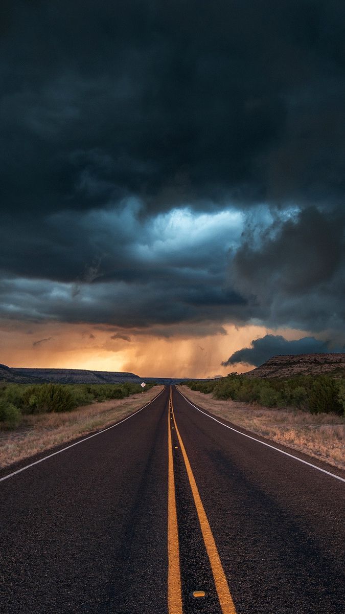A long road with storm clouds in the background - Texas