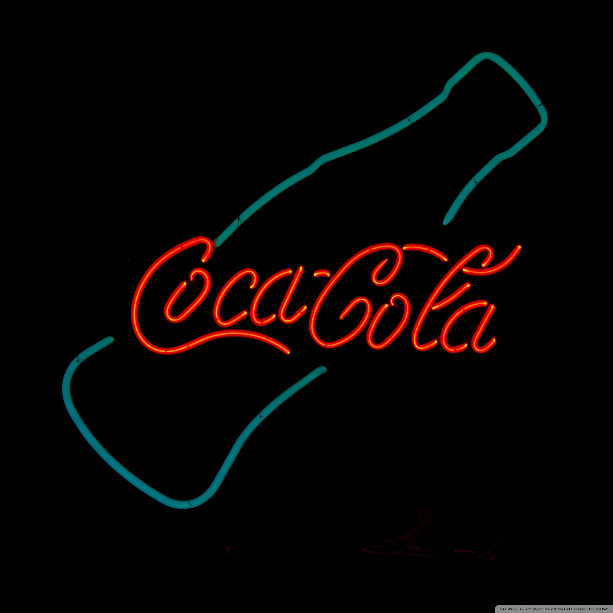 A neon sign that says coca cola - Texas