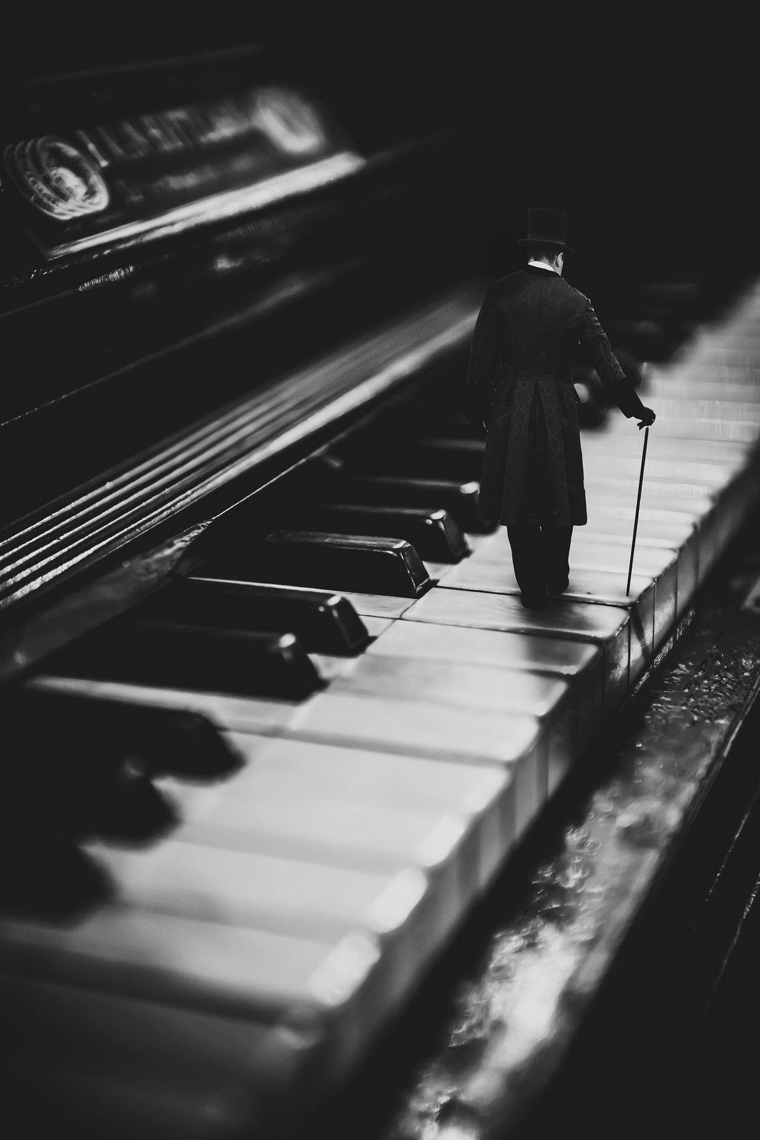 A man is standing on top of the piano - Piano