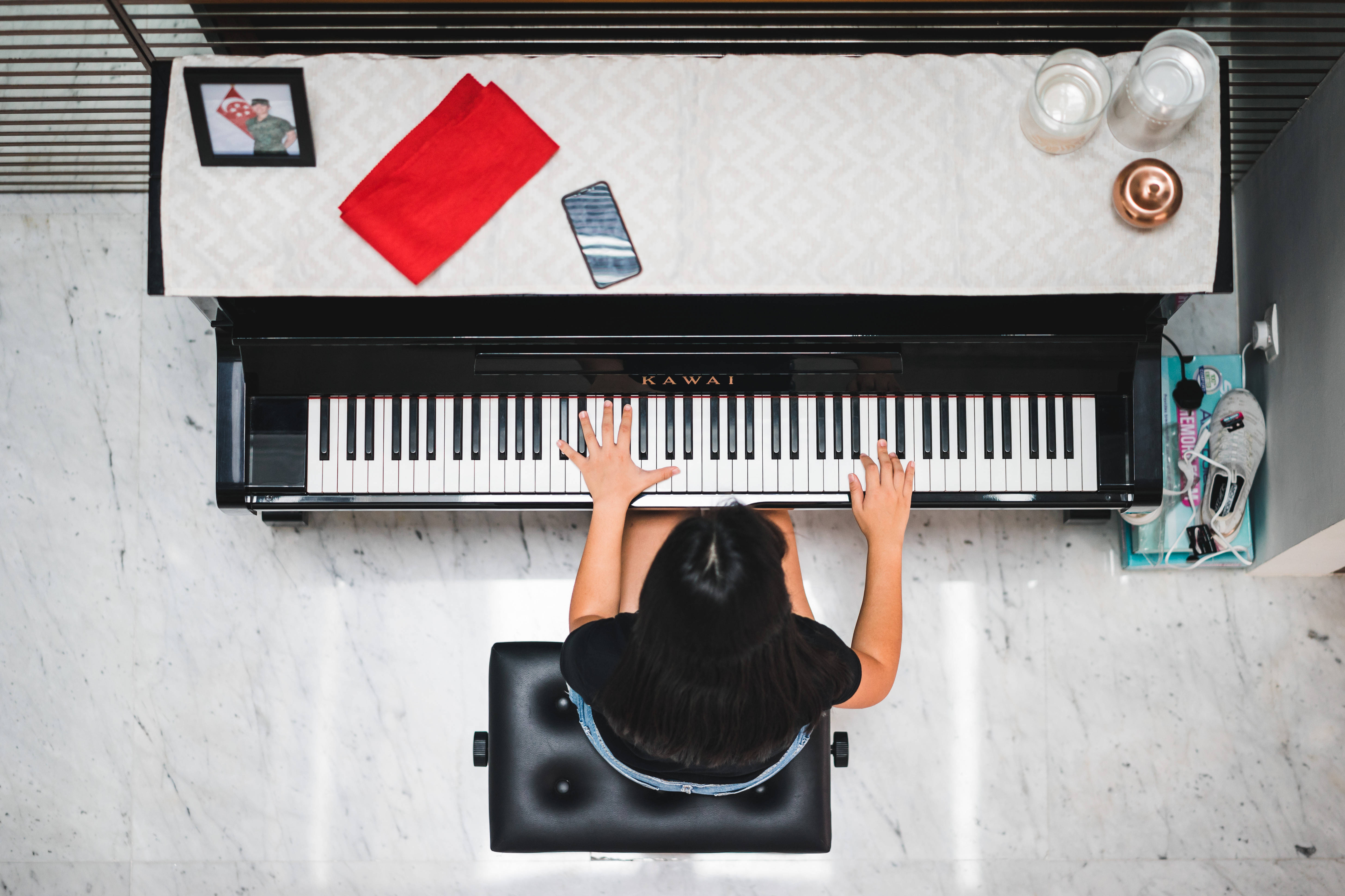 A woman sitting on top of an upright piano - Piano