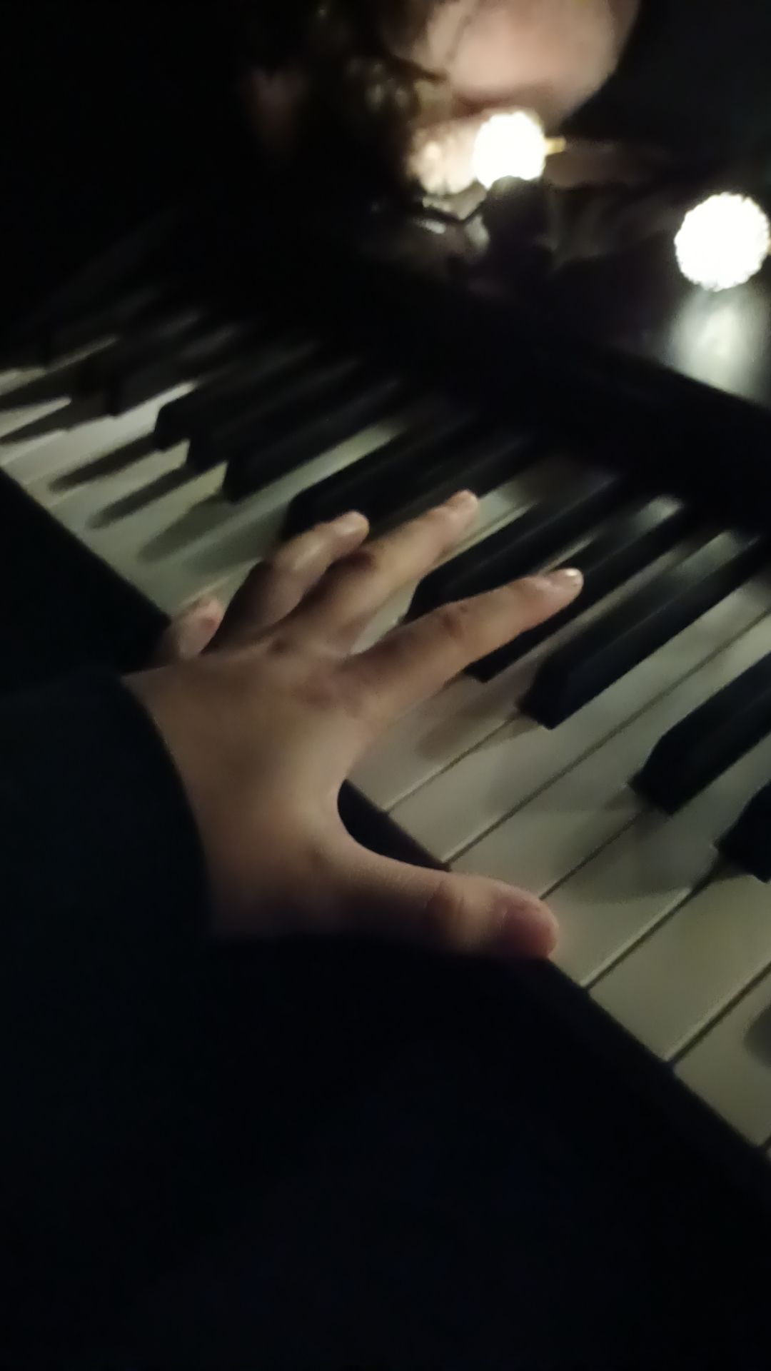 A person's hand on the keys of a piano. - Piano