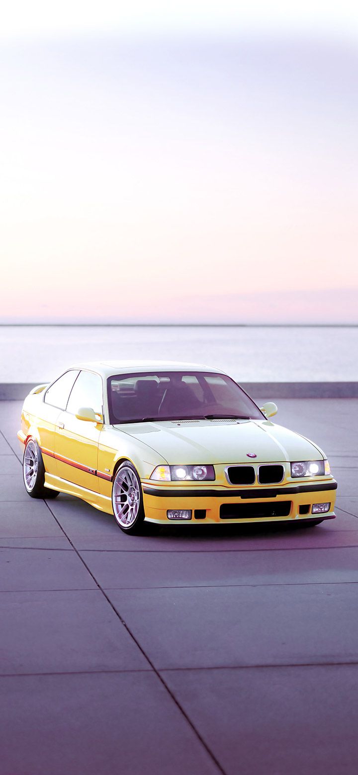 A yellow car with wheels on the ground - BMW