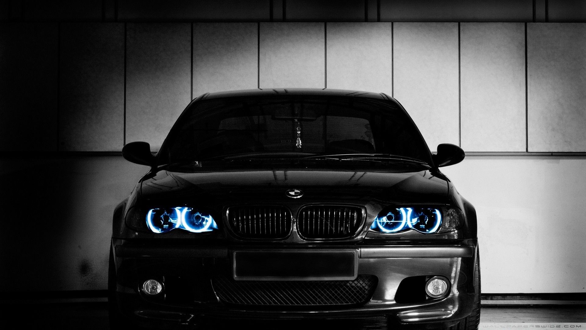 A black bmw car with blue headlights - BMW