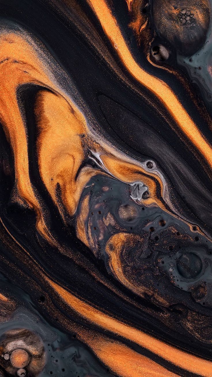 An abstract image of black and gold paint swirled together - Dark orange, marble