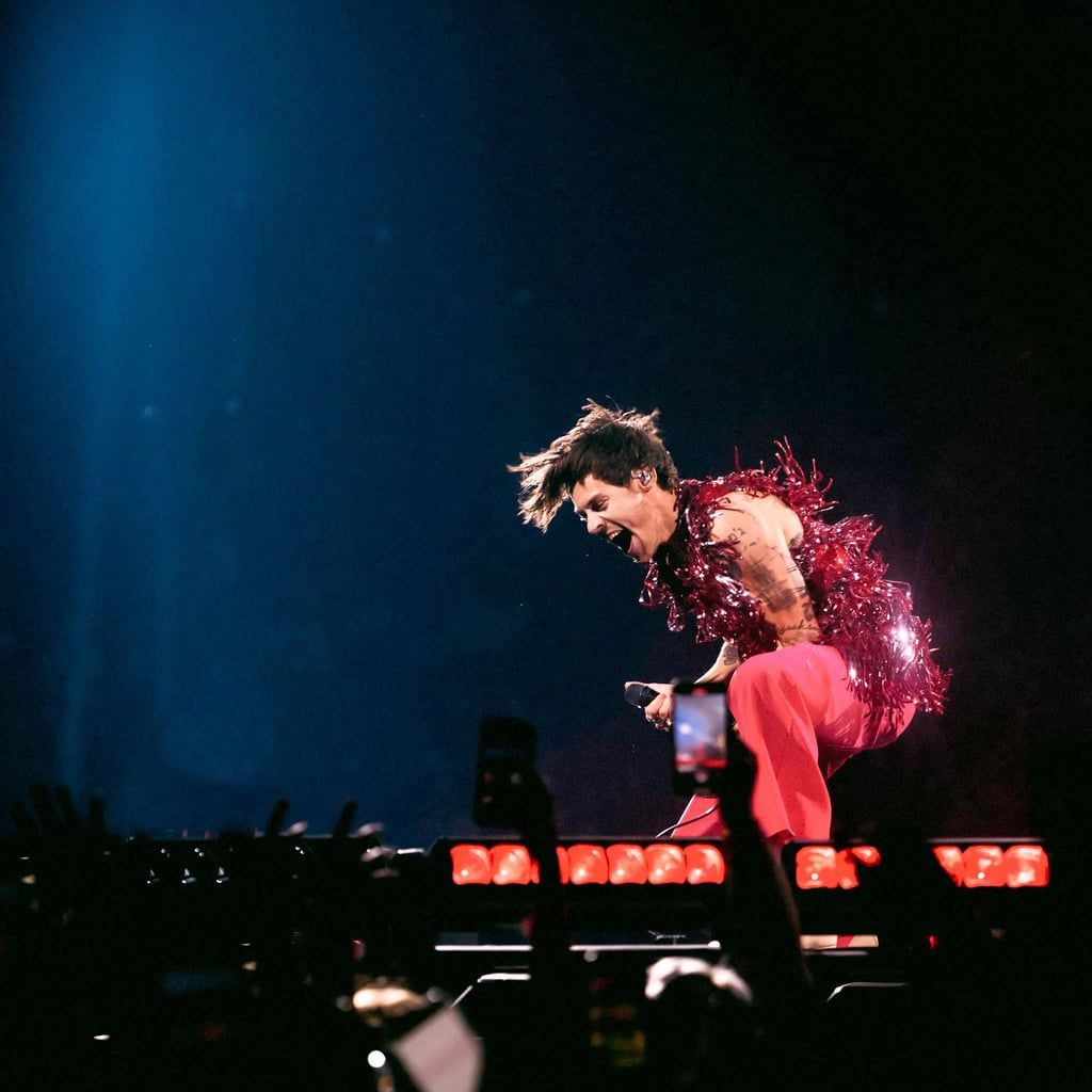 Harry Styles performing on stage in a red sparkly suit - Harry Styles