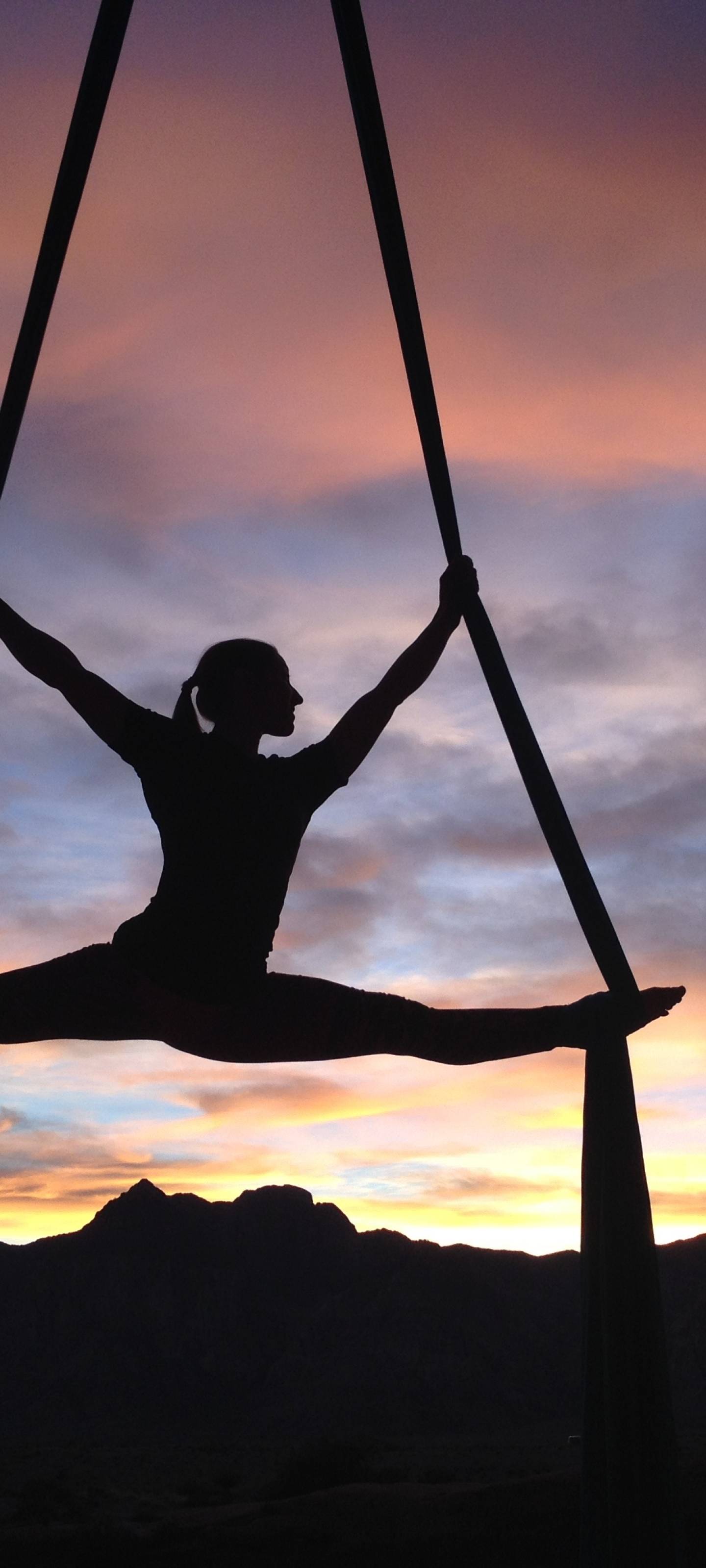 A woman is doing yoga on the silks - Gymnastics