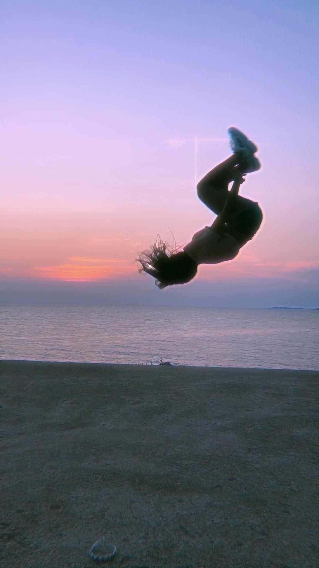 A person doing tricks on skateboard at sunset - Gymnastics