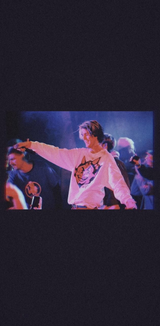 Justin Bieber with his left arm outstretched, wearing a white shirt with a picture of a fox on it. - Lil Peep