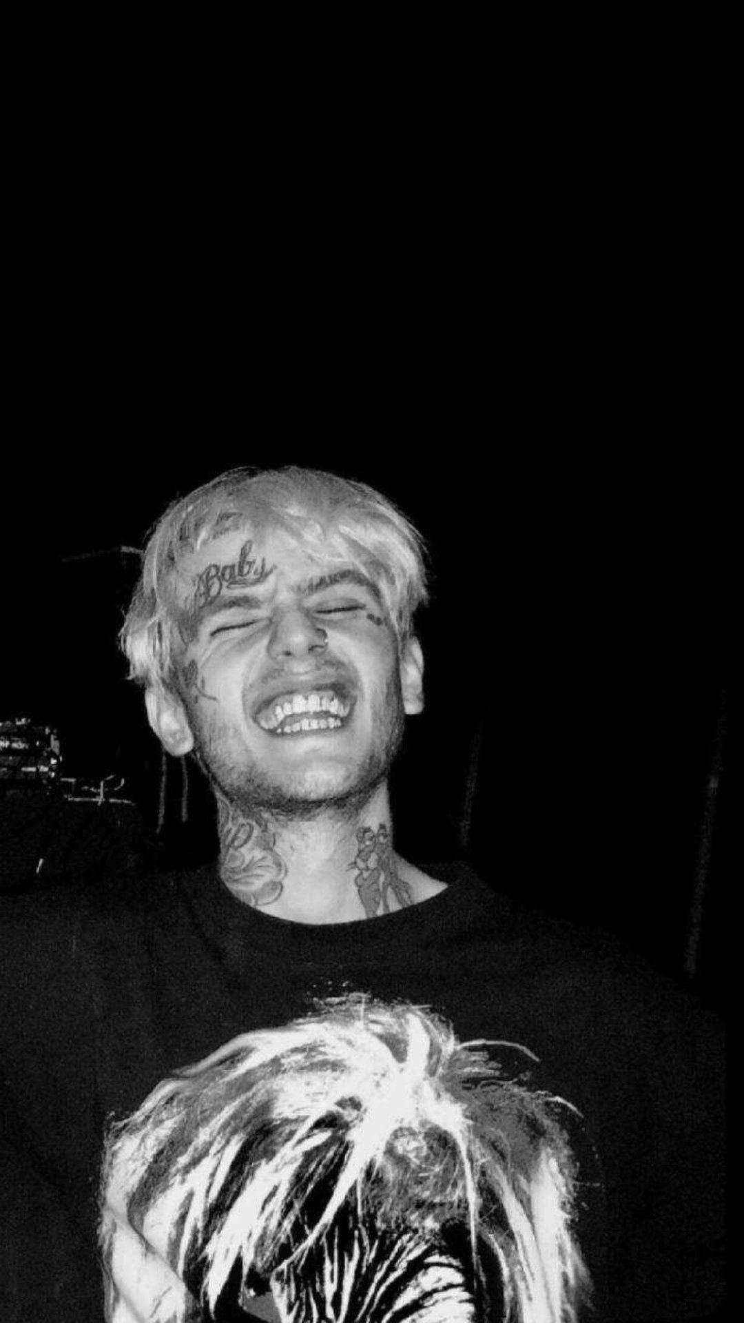 A man with tattoos and white hair smiling - Lil Peep