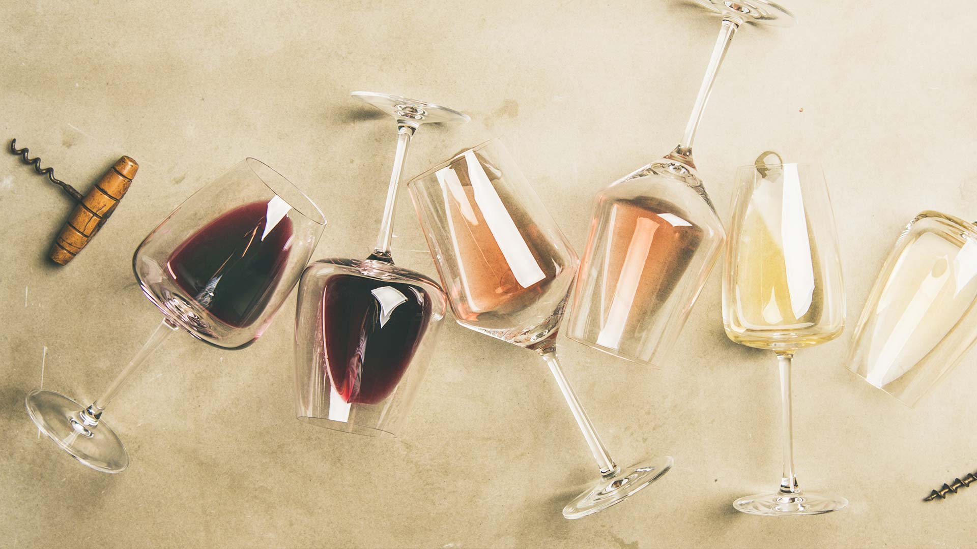 A collection of wine glasses filled with red, white and rosé wine - Champagne