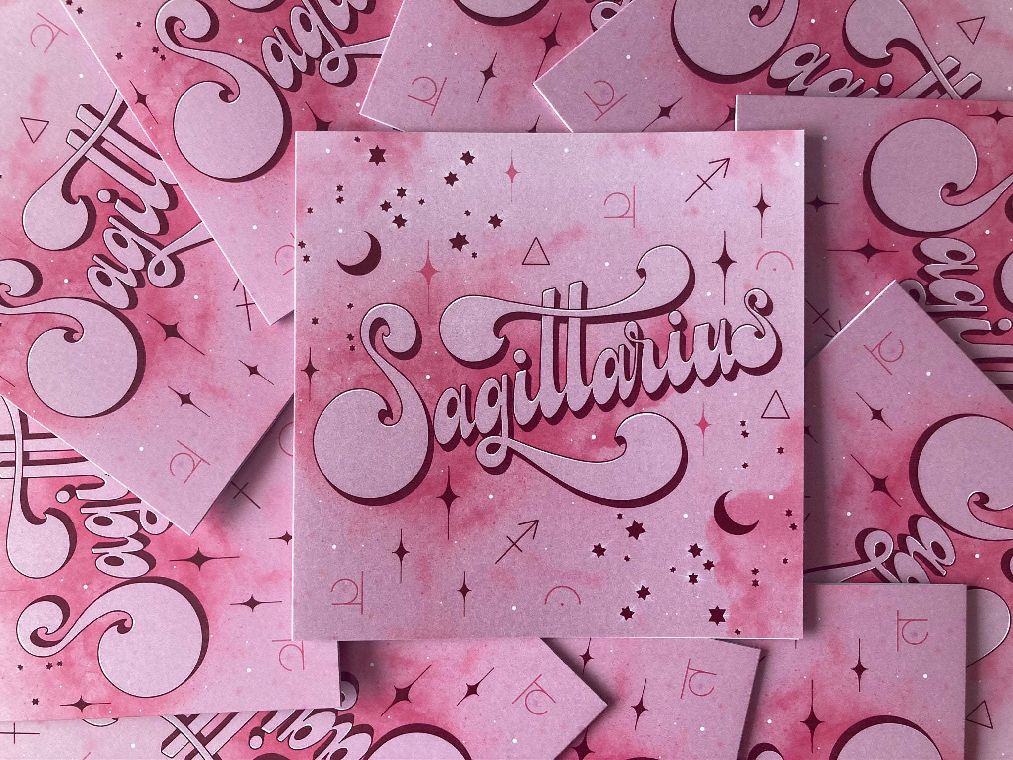 A stack of pink cards with the word astrology on them - Sagittarius