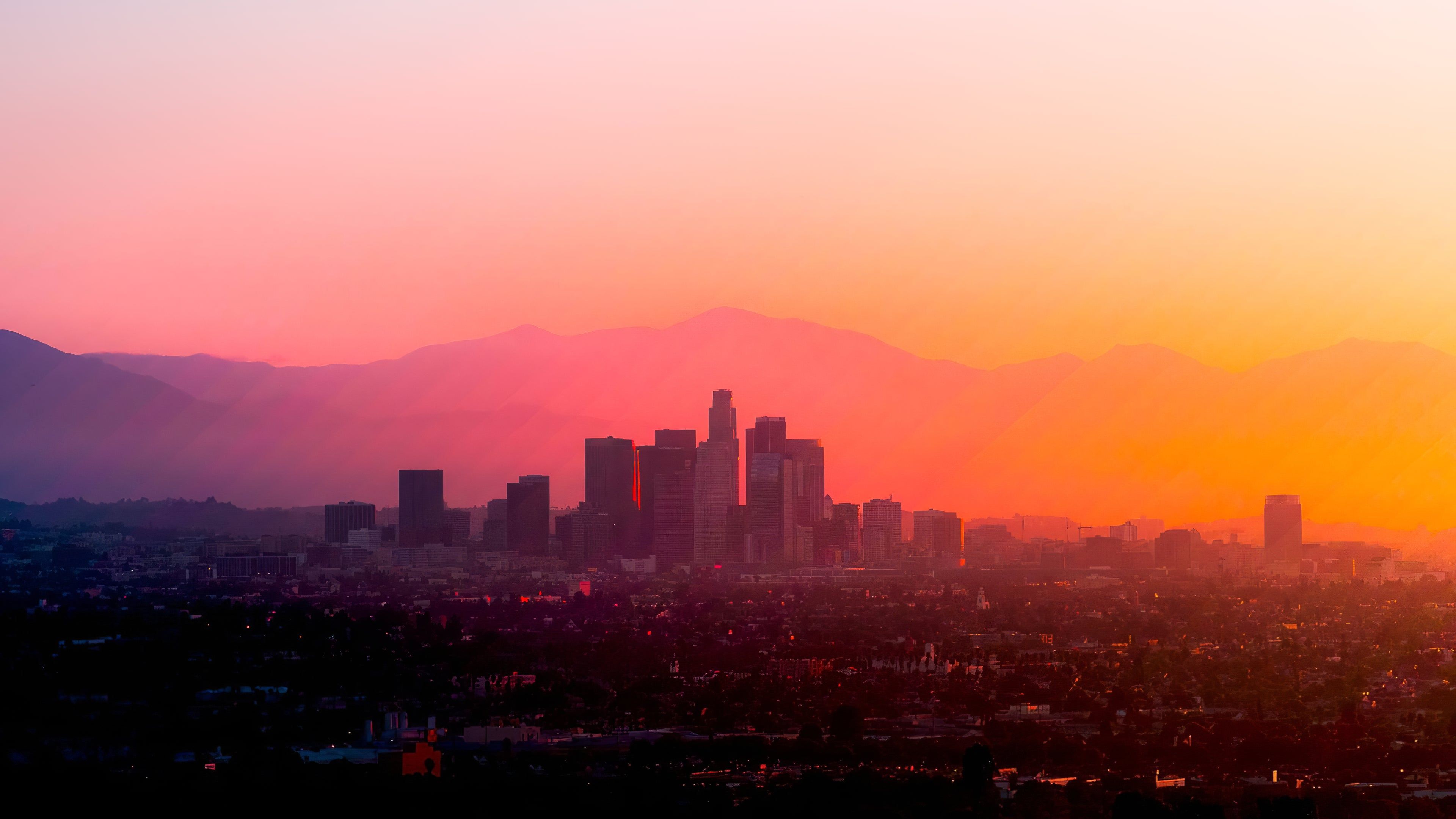 A city skyline at sunset with mountains in the background - Los Angeles