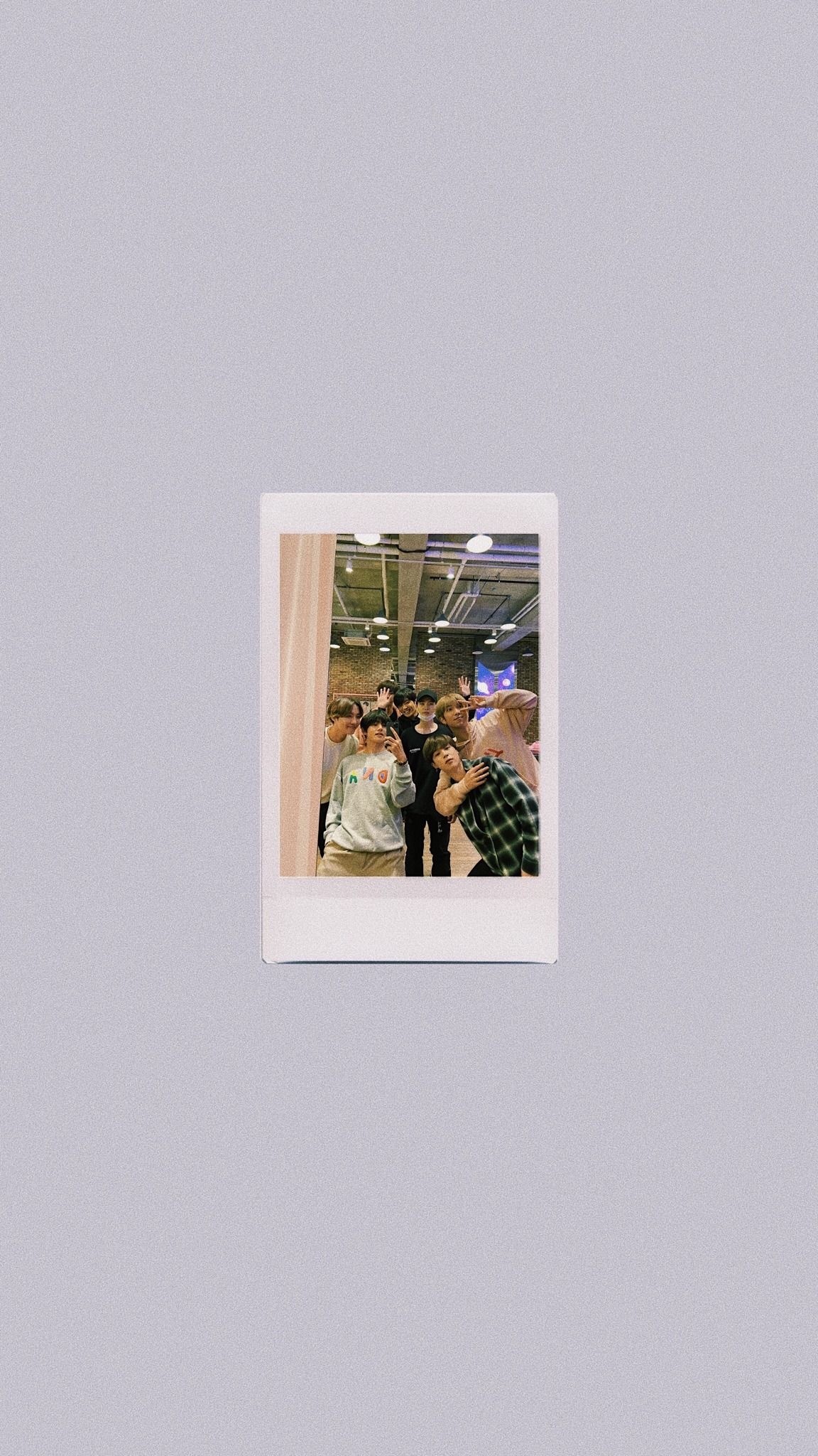 A polaroid picture of a group of people in a white room. - Polaroid