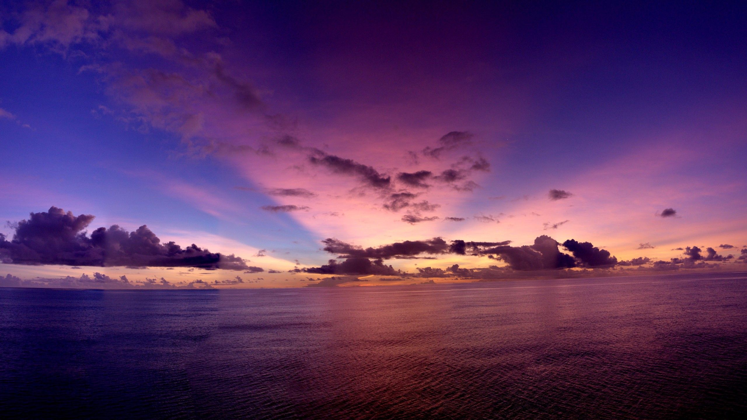A beautiful sunset over the ocean with a purple and blue sky - Sunset