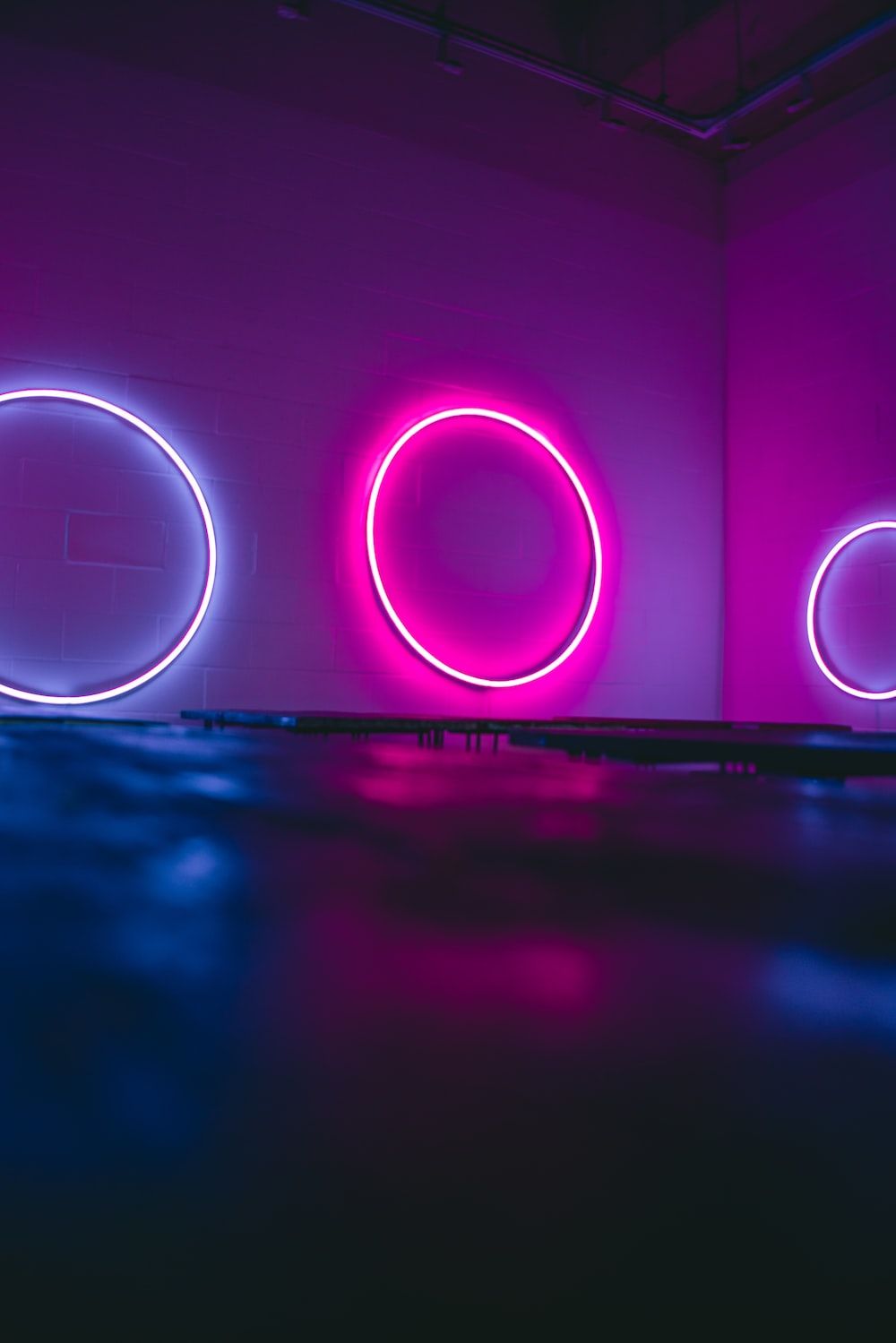 A room with three neon circles on the wall - Neon pink