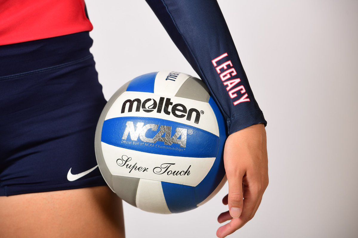 A woman holding up an ncaa volleyball - Volleyball
