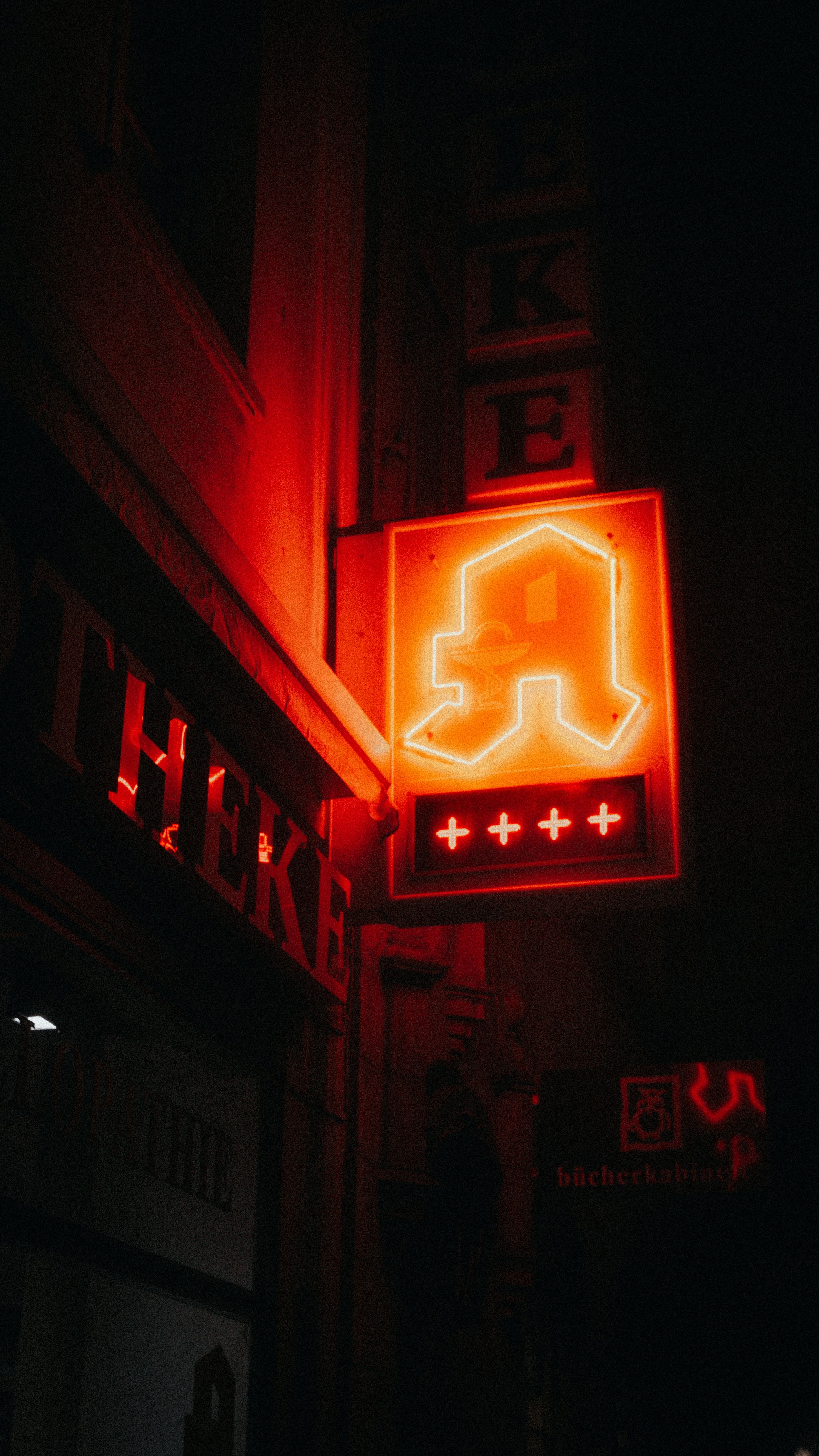 A neon sign on the side of building - Neon orange