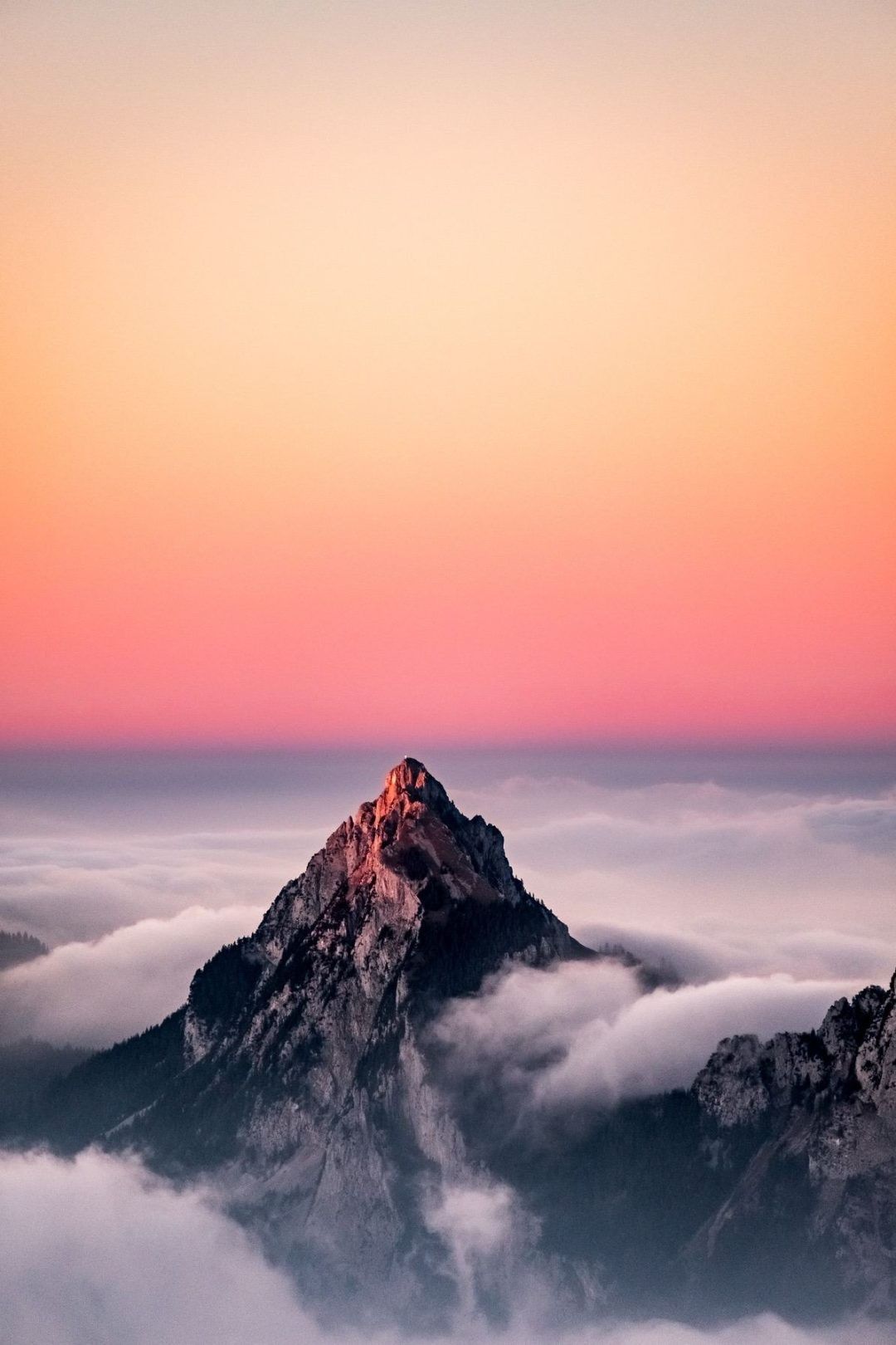 A mountain peak with a pink sky in the background - Mountain