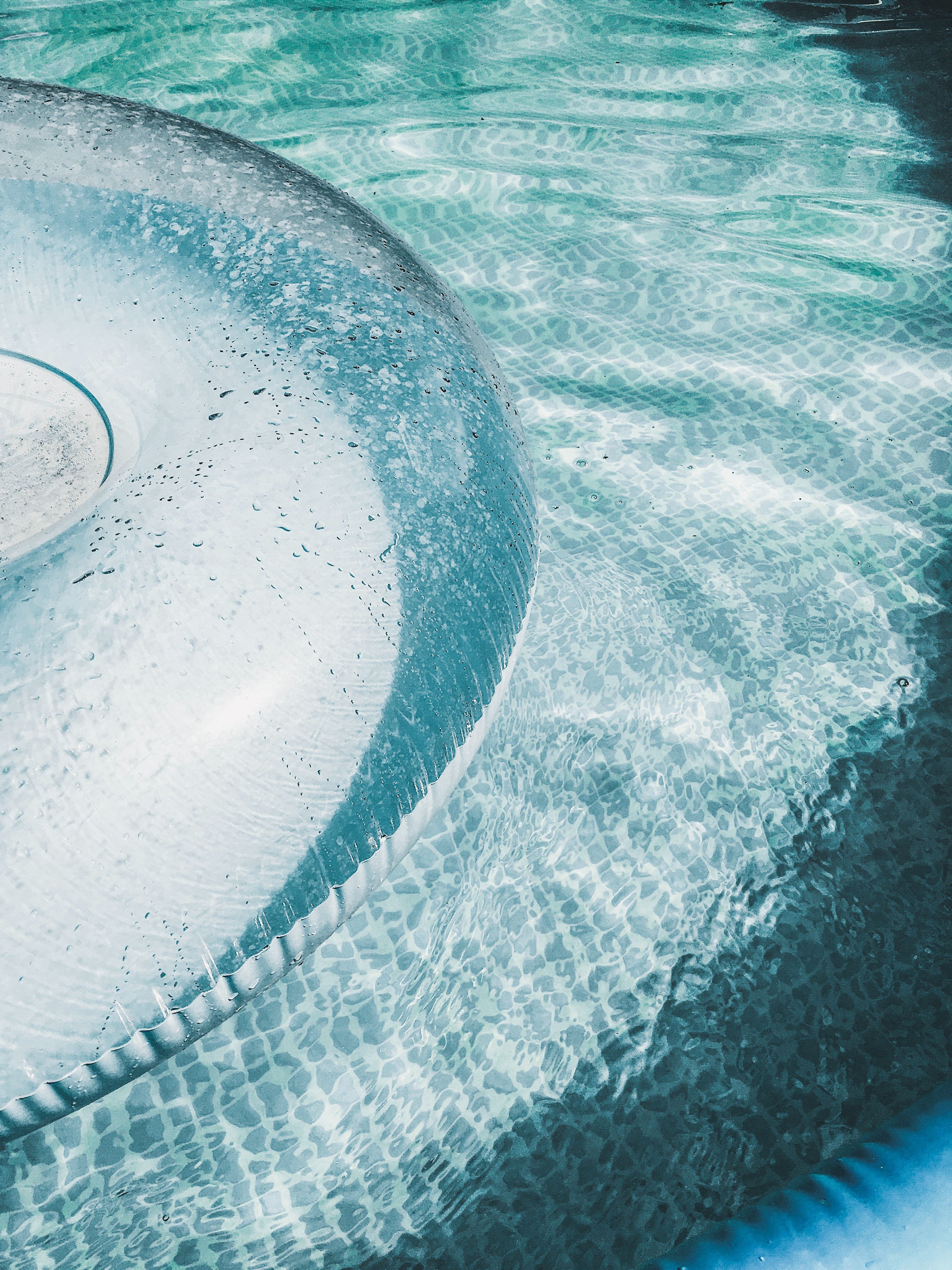 A close up of a clear inflatable pool float in a pool - Water
