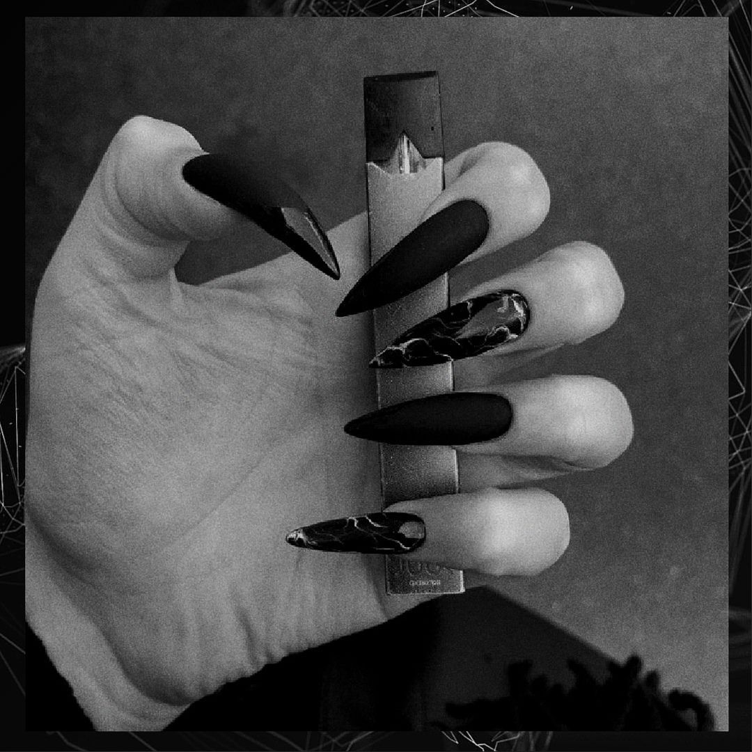 Black and white photo of a hand with long nails holding a ruler. - Nails