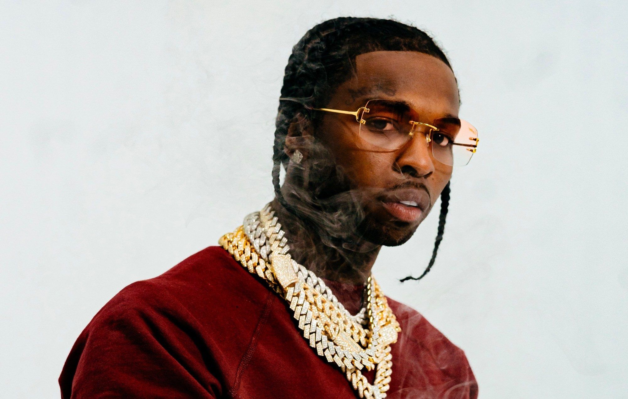 A man with gold chains and glasses - Pop Smoke