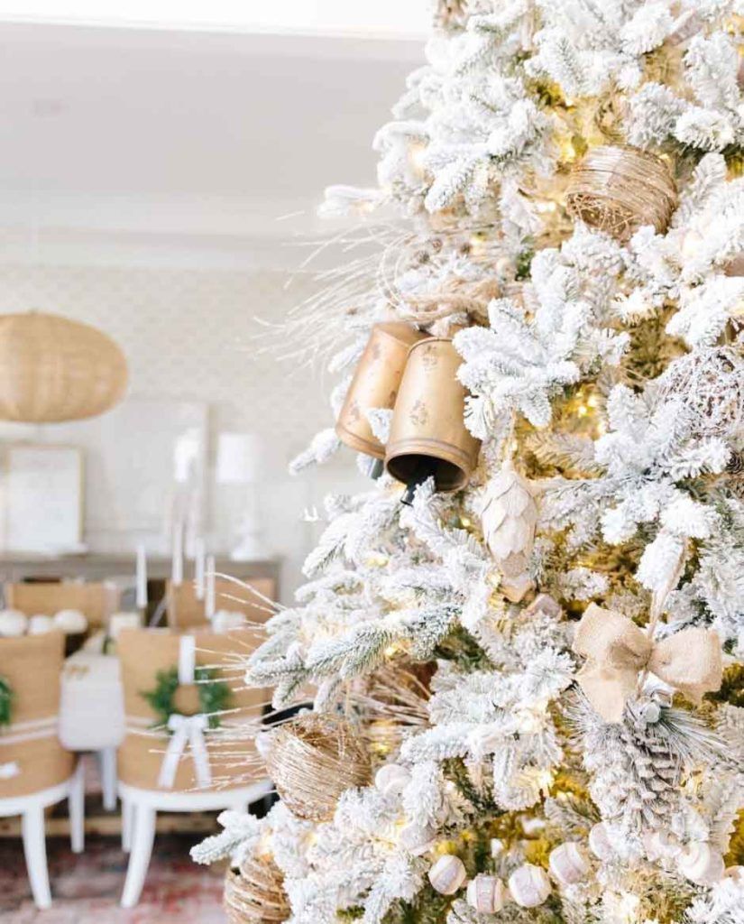 A white Christmas tree with bells and white and gold decorations. - White Christmas
