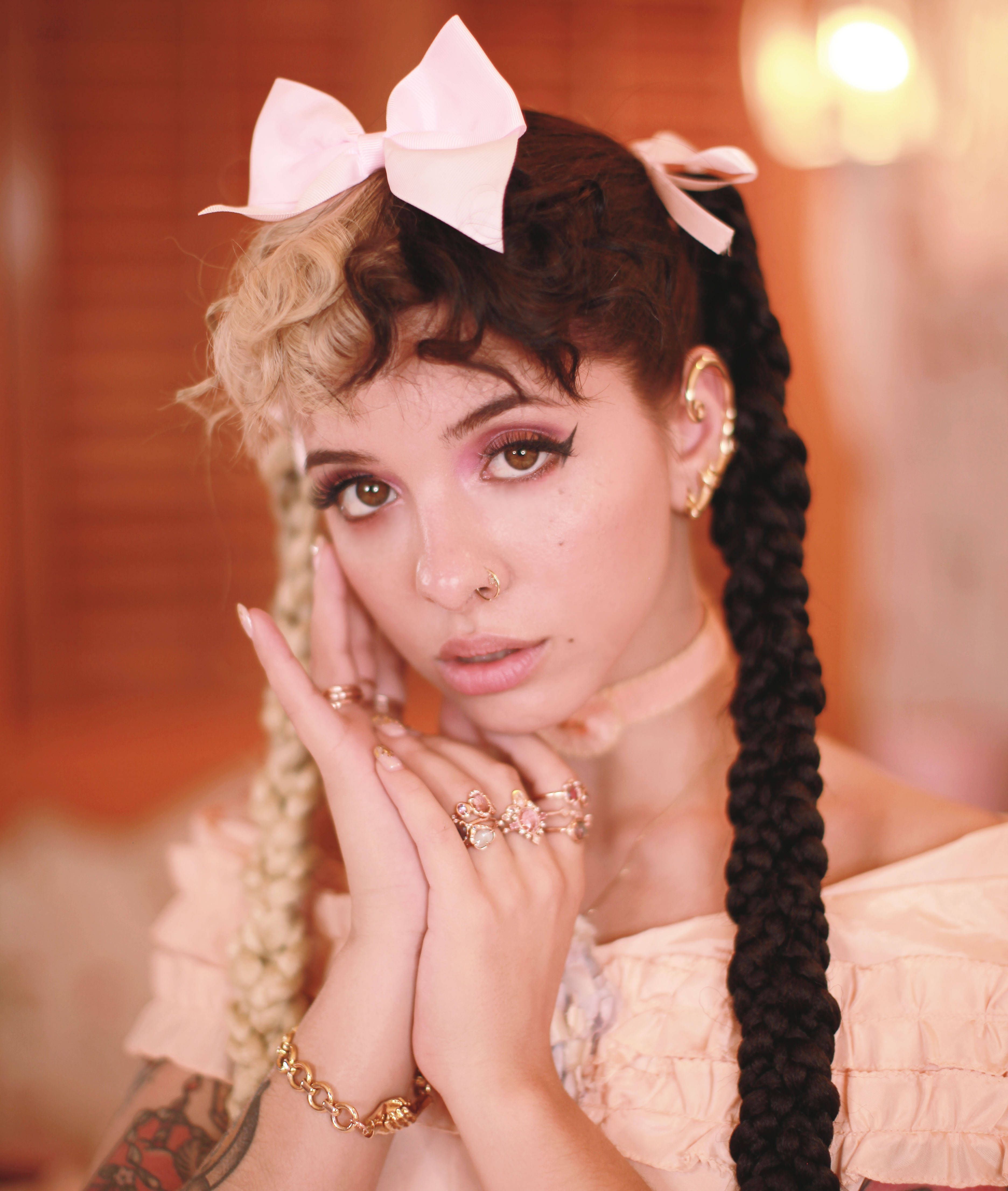 The 24-year-old musician is a mixed-race woman with light brown skin and dark brown hair. - Melanie Martinez