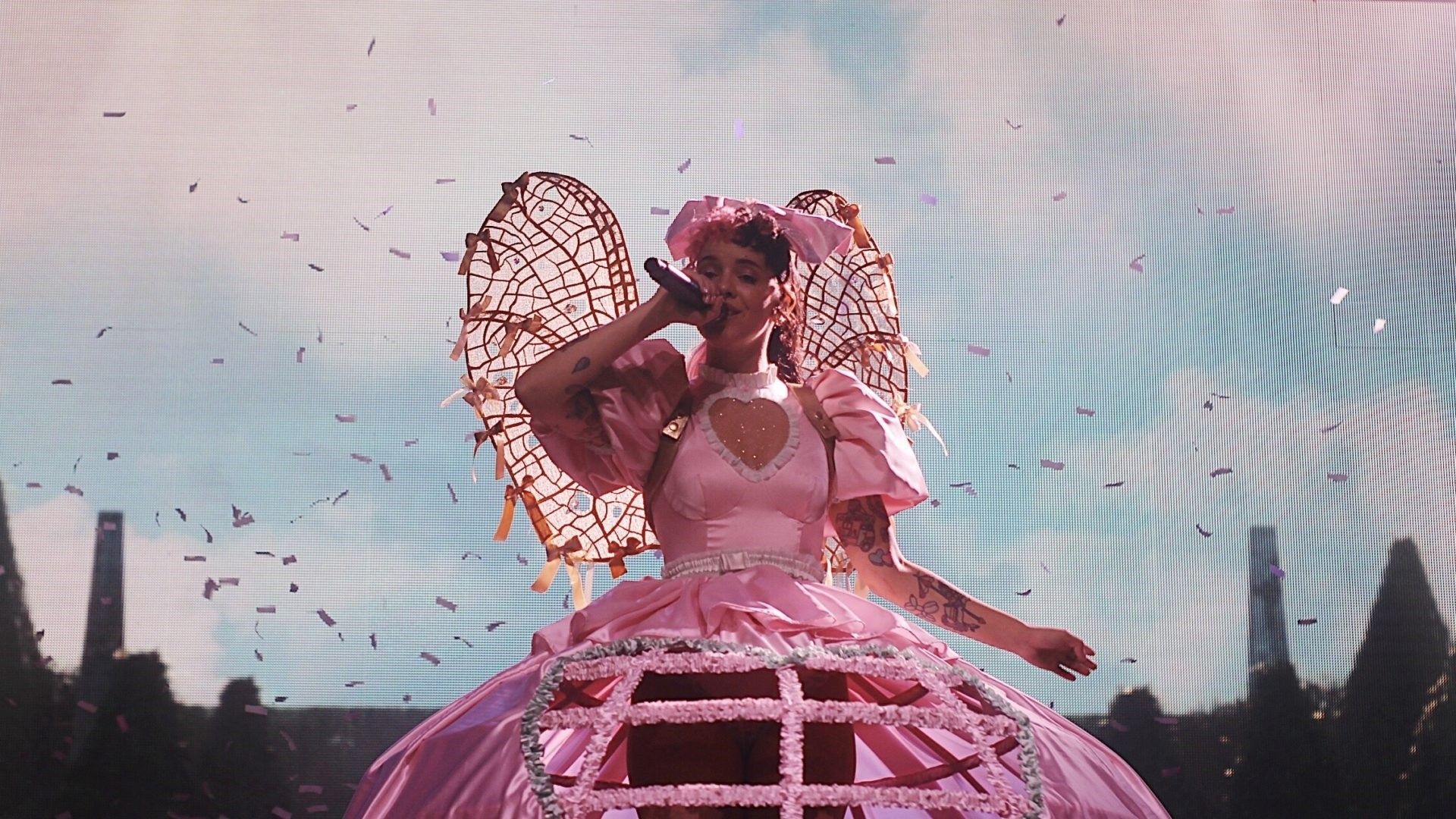 Lorde in a pink dress singing on stage - Melanie Martinez