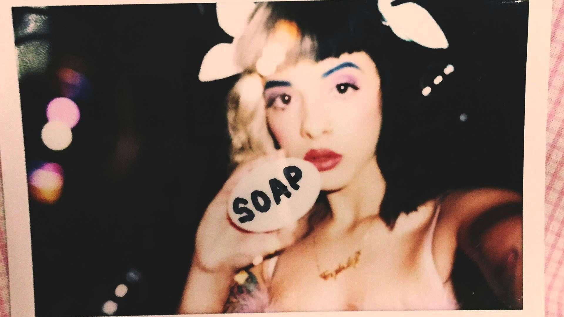 A woman holding up soap in front of her face - Melanie Martinez