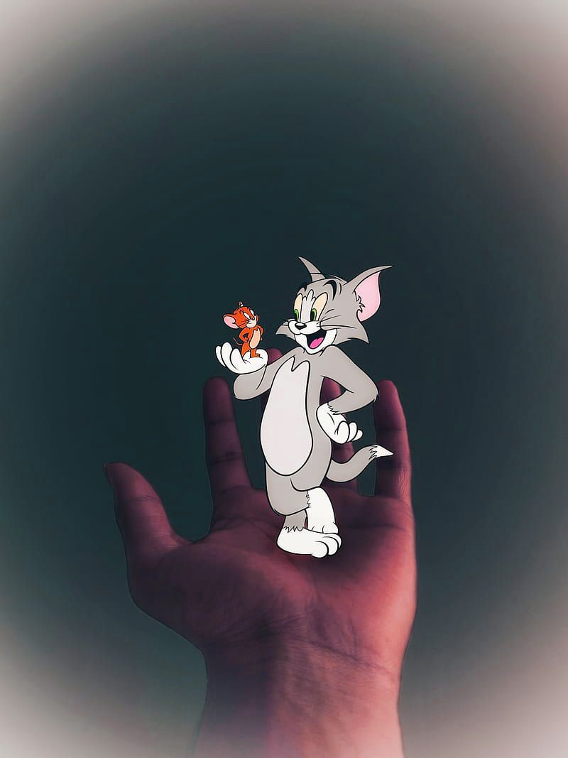 A cartoon image of Tom and Jerry held in a hand - Tom and Jerry
