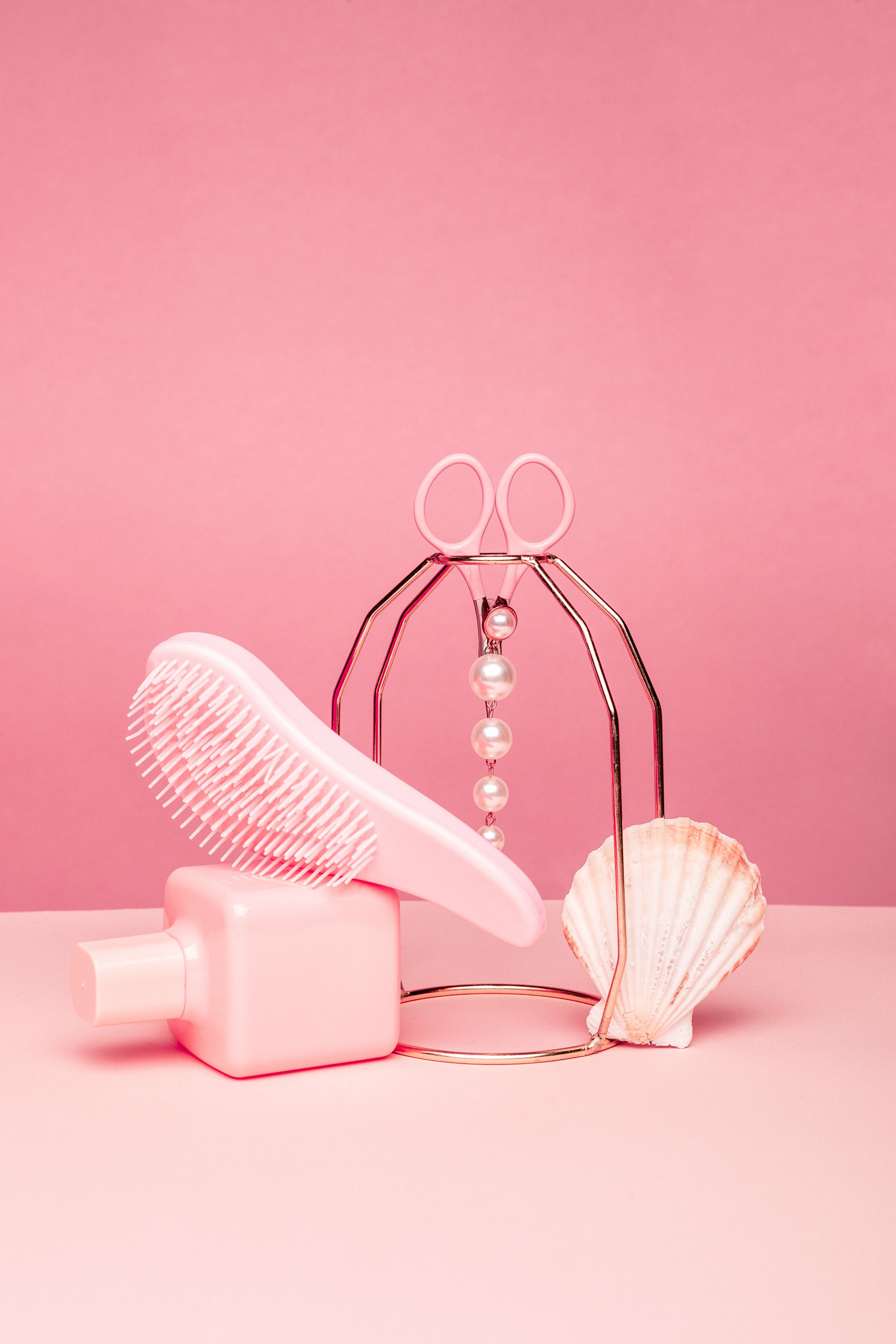 The image features various beauty products arranged against a pink background. - Danish