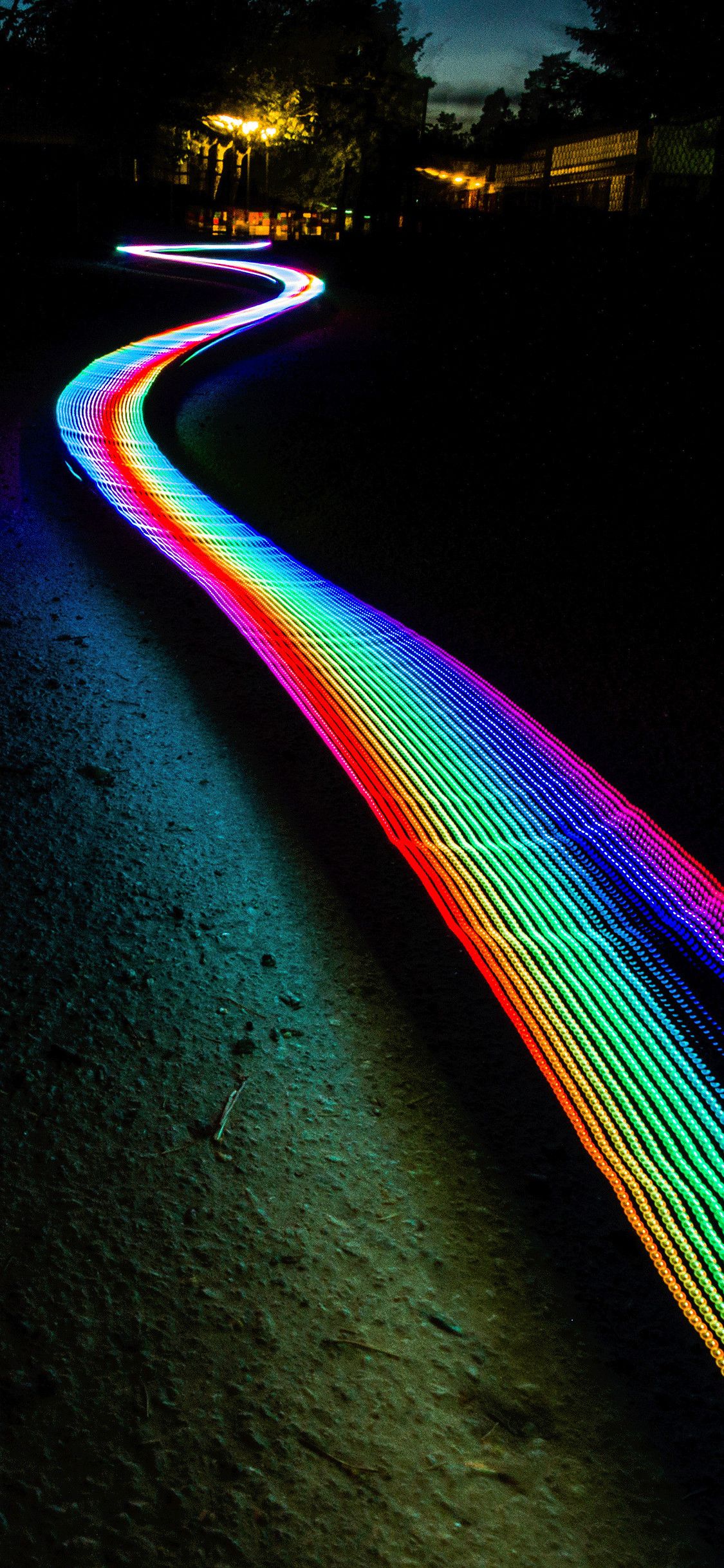 A rainbow colored light on the ground - Neon