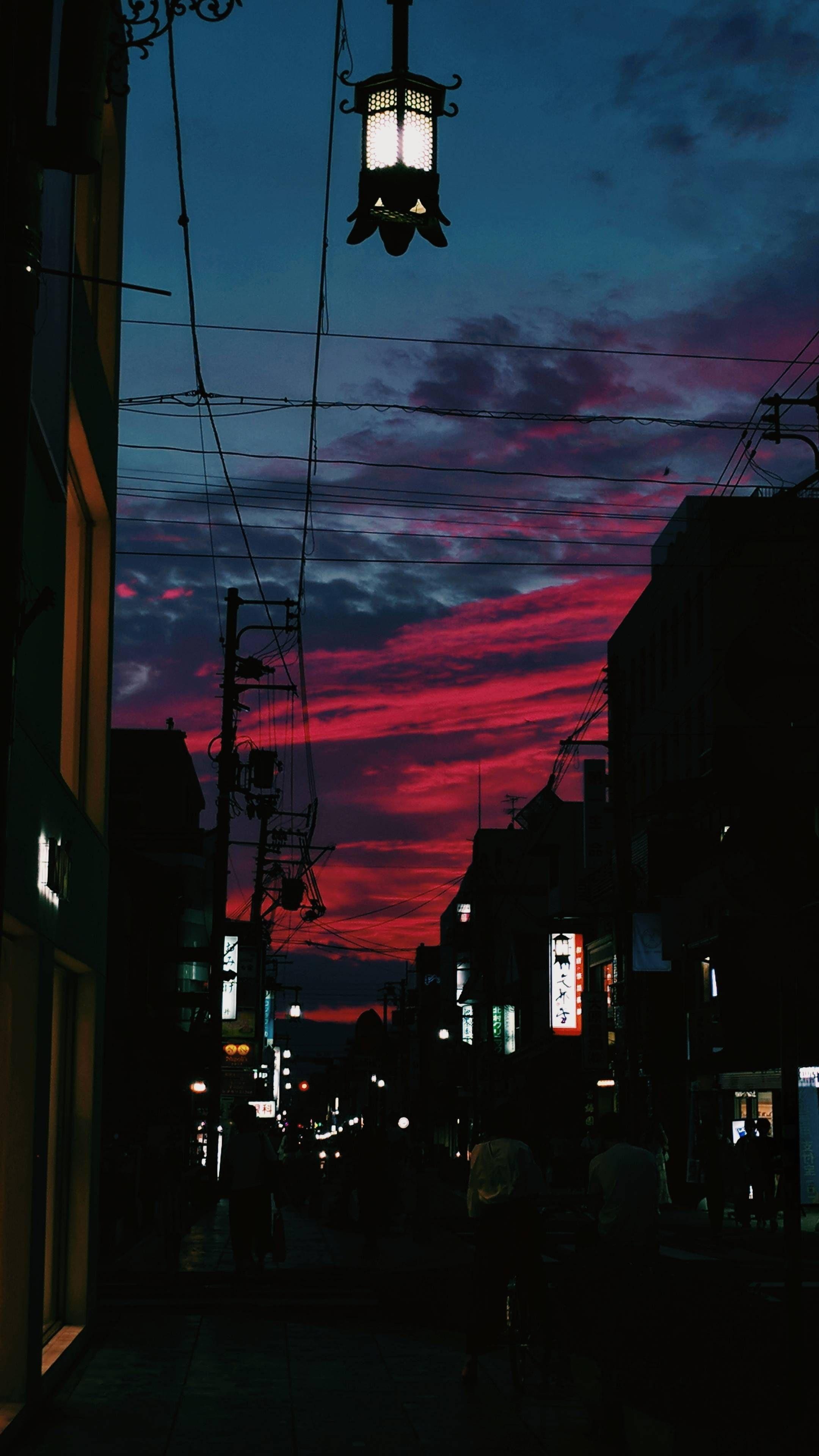 A beautiful sunset over a city street with tall buildings. - Phone, Japanese, Japan
